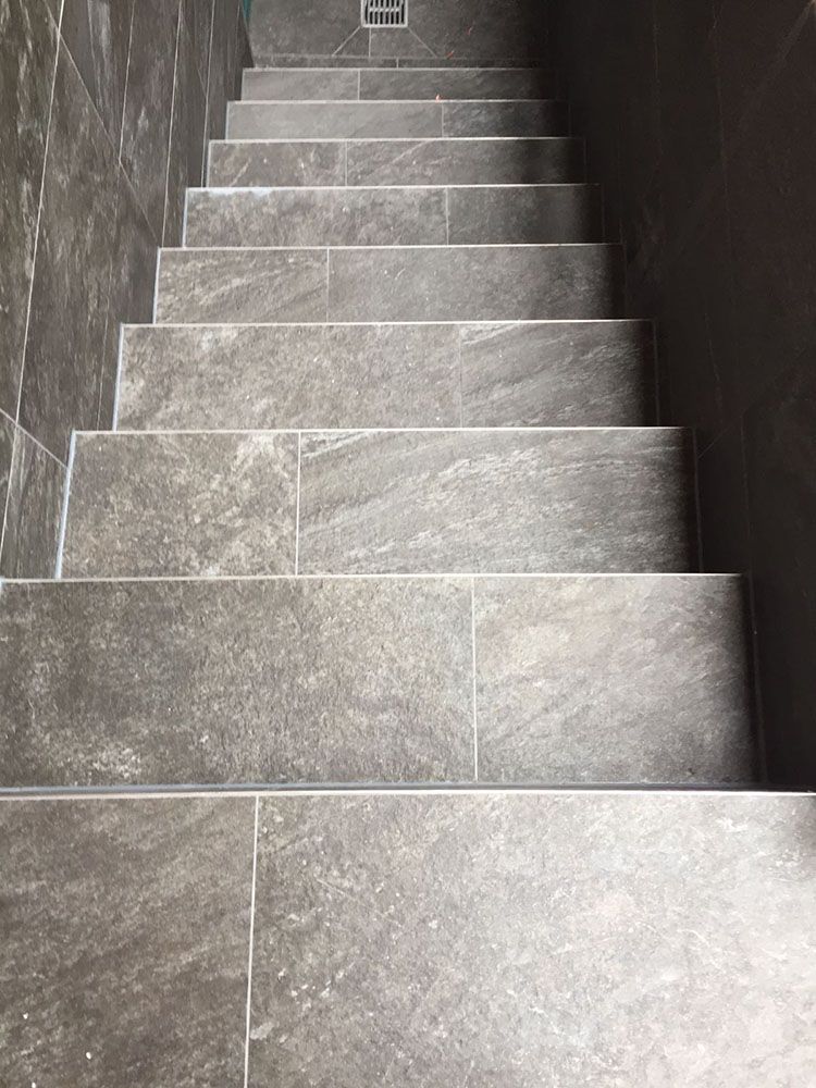 Eine Nahaufnahme einer gefliesten Treppe, die zu einer Wand hinaufführt.