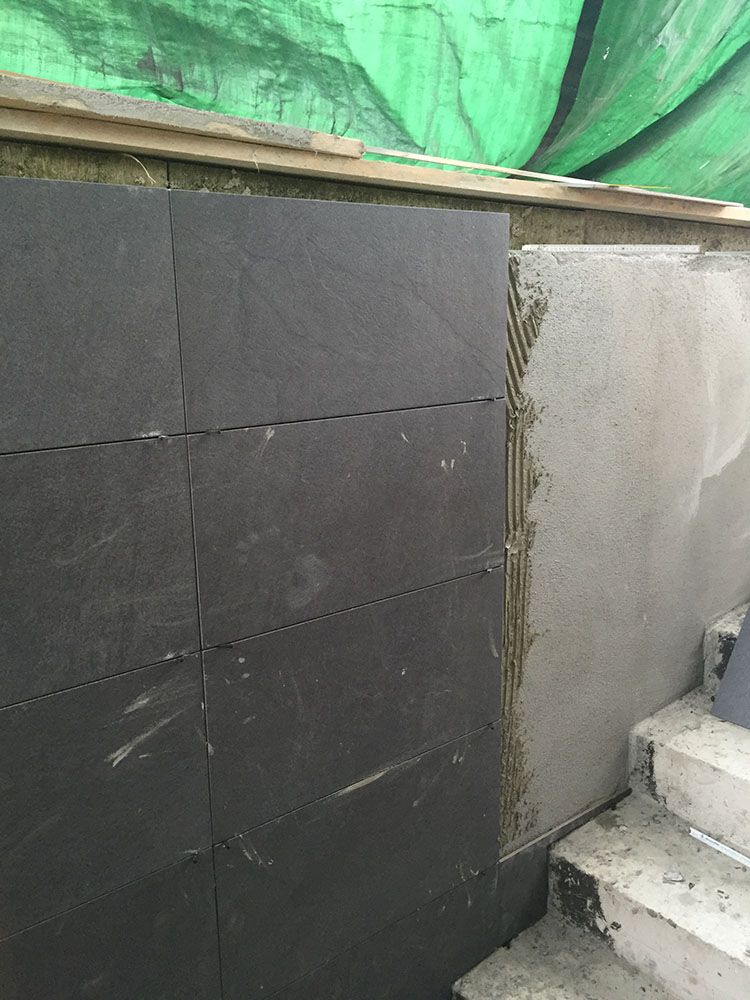 Eine Wand mit Fliesen neben der Treppe.