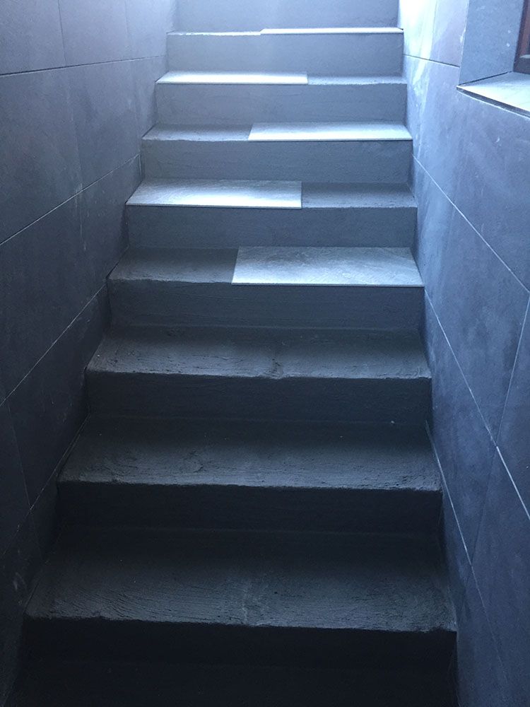 Eine Treppe, die zu einem dunklen Raum hinaufführt.