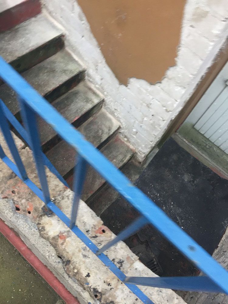 Ein blaues Geländer, das zu einer Treppe hinaufführt.