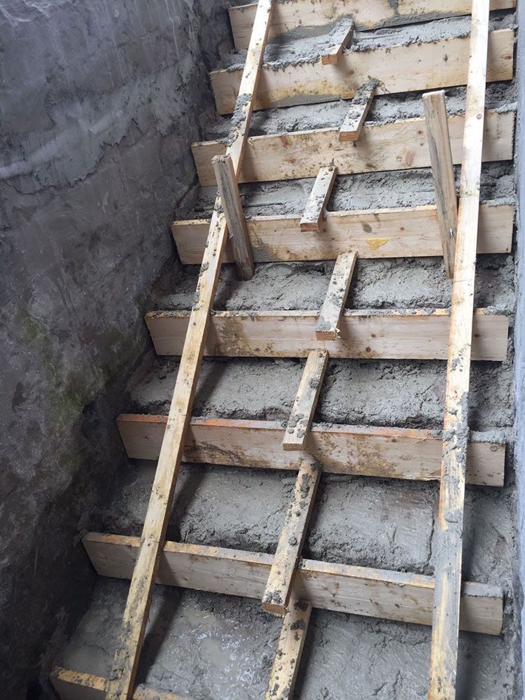 In einem Keller wird eine Holztreppe gebaut.