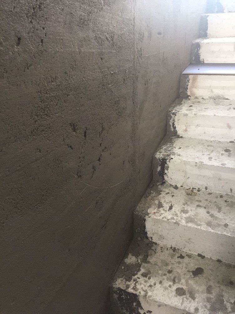 Eine Nahaufnahme einer Betonwand neben einer Treppe.