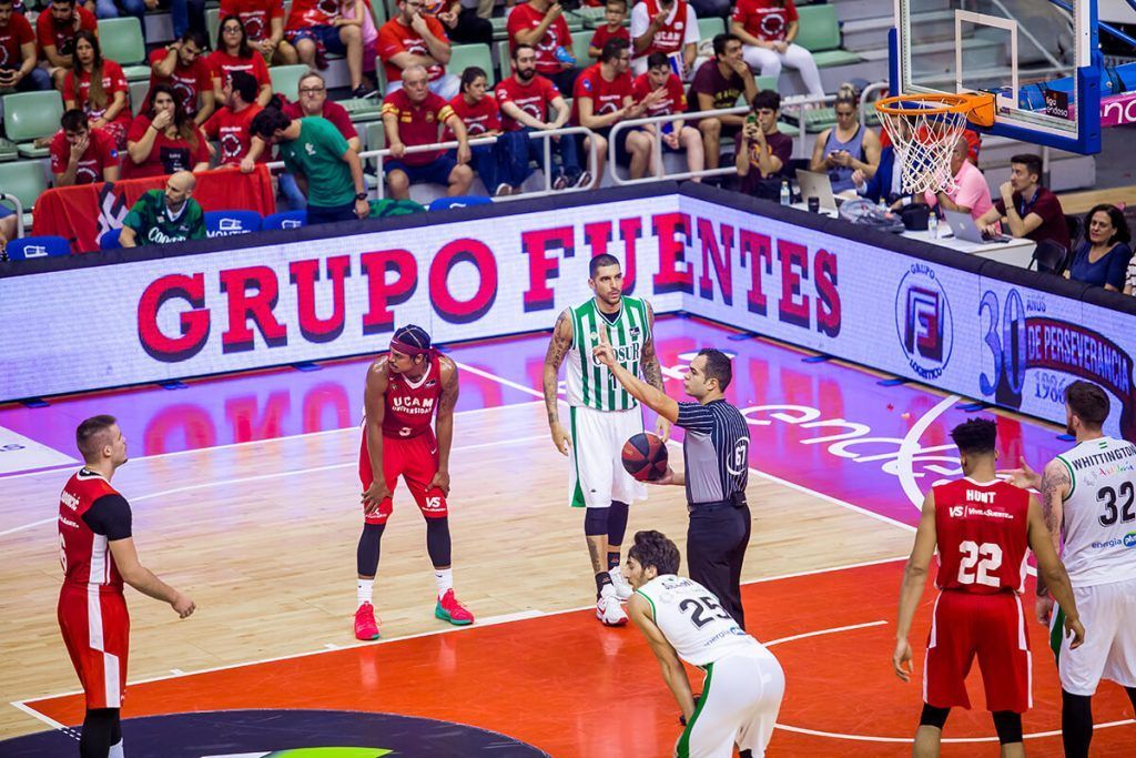 Un grupo de jugadores de baloncesto está jugando un partido en una cancha.