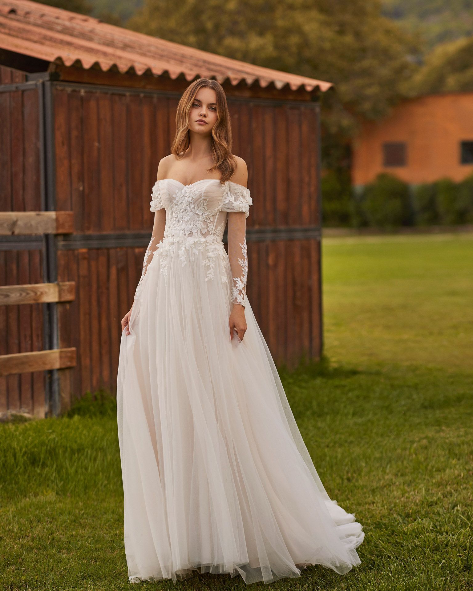 Langes Brautkleid, gerade geschnitten. Aus Tüll mit Spitzendetails, Herzausschnitt, abnehmbaren Ärmeln und geknöpftem Rücken.