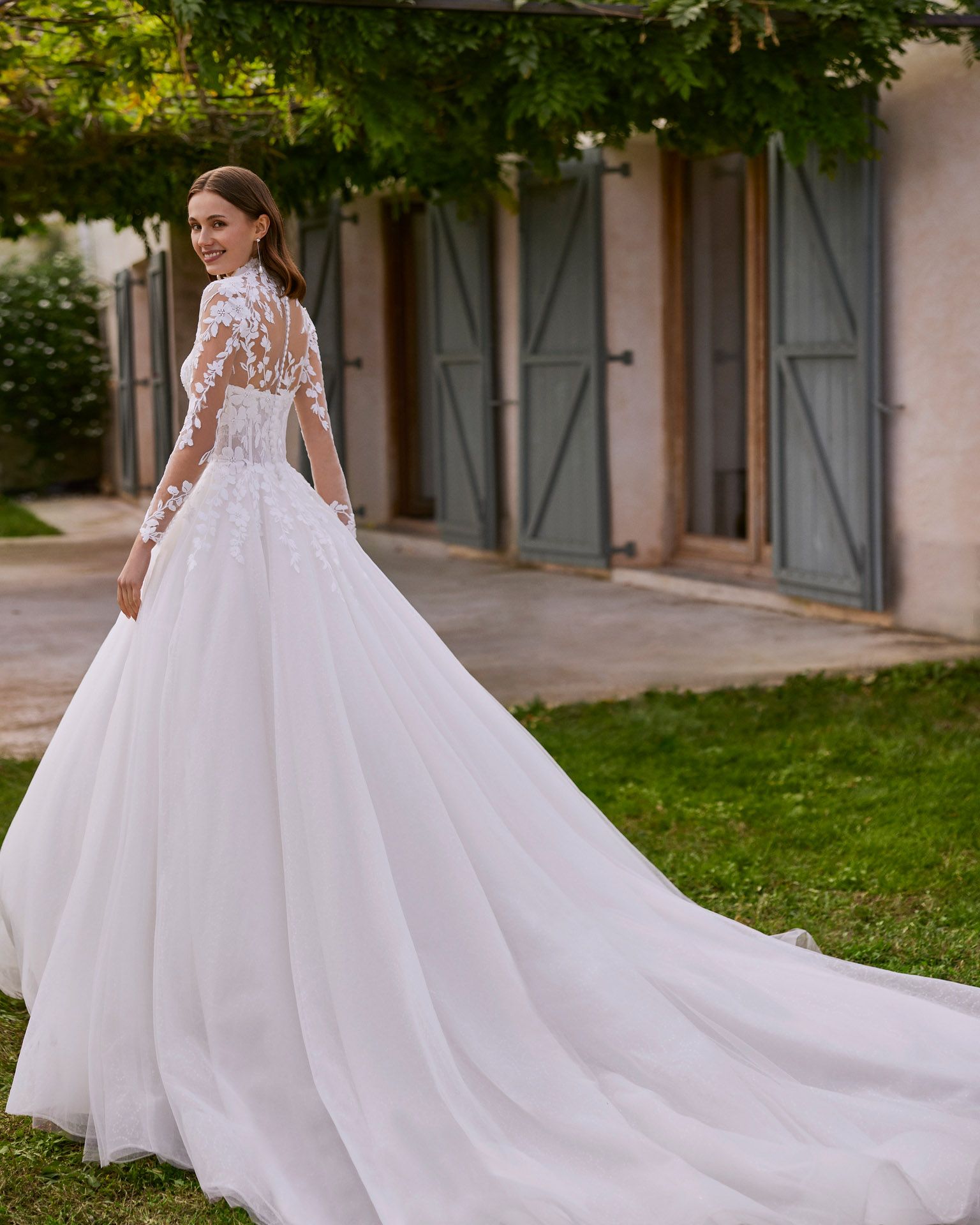 Eine Frau in einem weißen Brautkleid steht vor einem Gebäude.