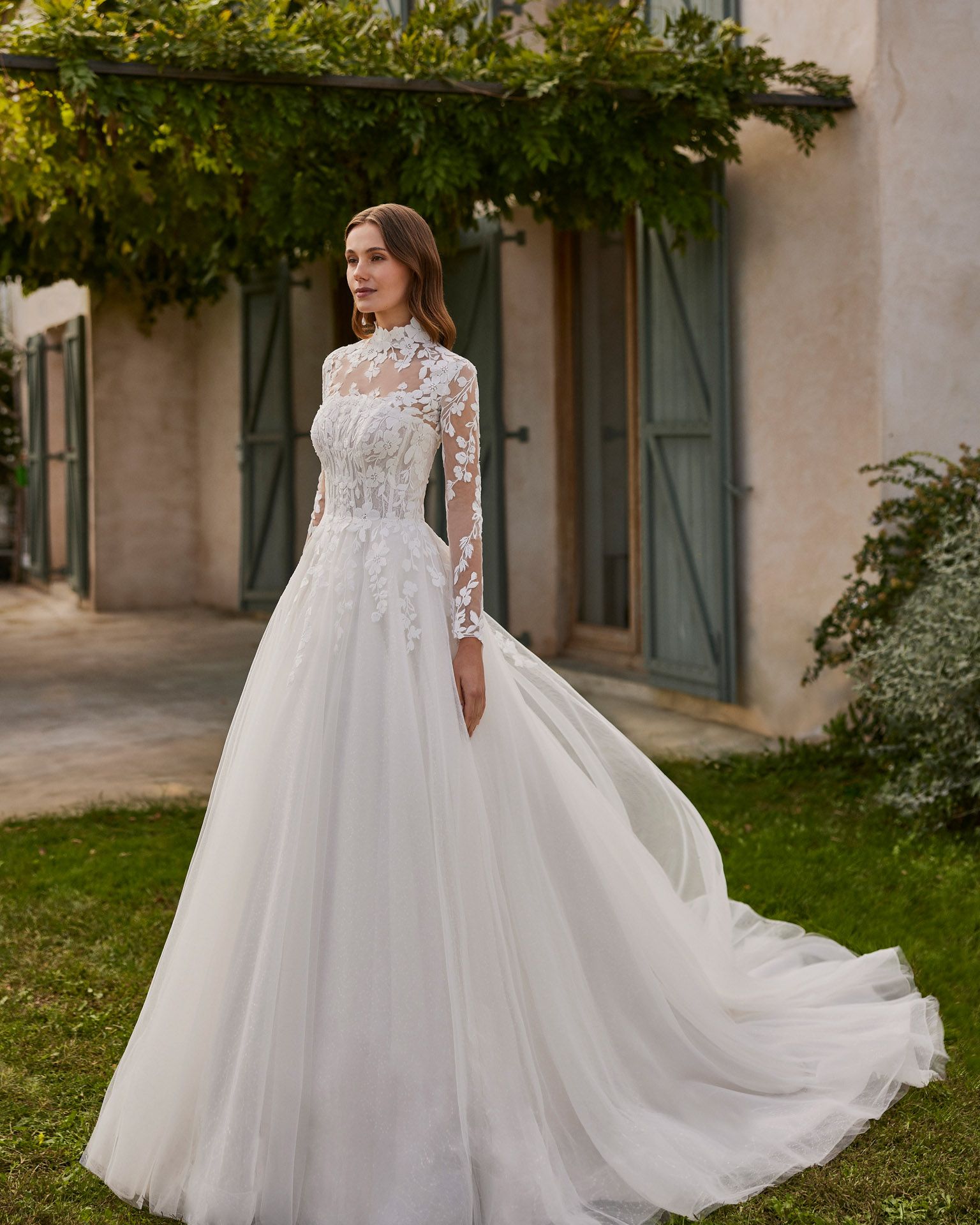 Langes Brautkleid, zweiteilig und A-Linie. Aus Tüll und Spitze mit trägerlosem Ausschnitt und Spitzenjacke.