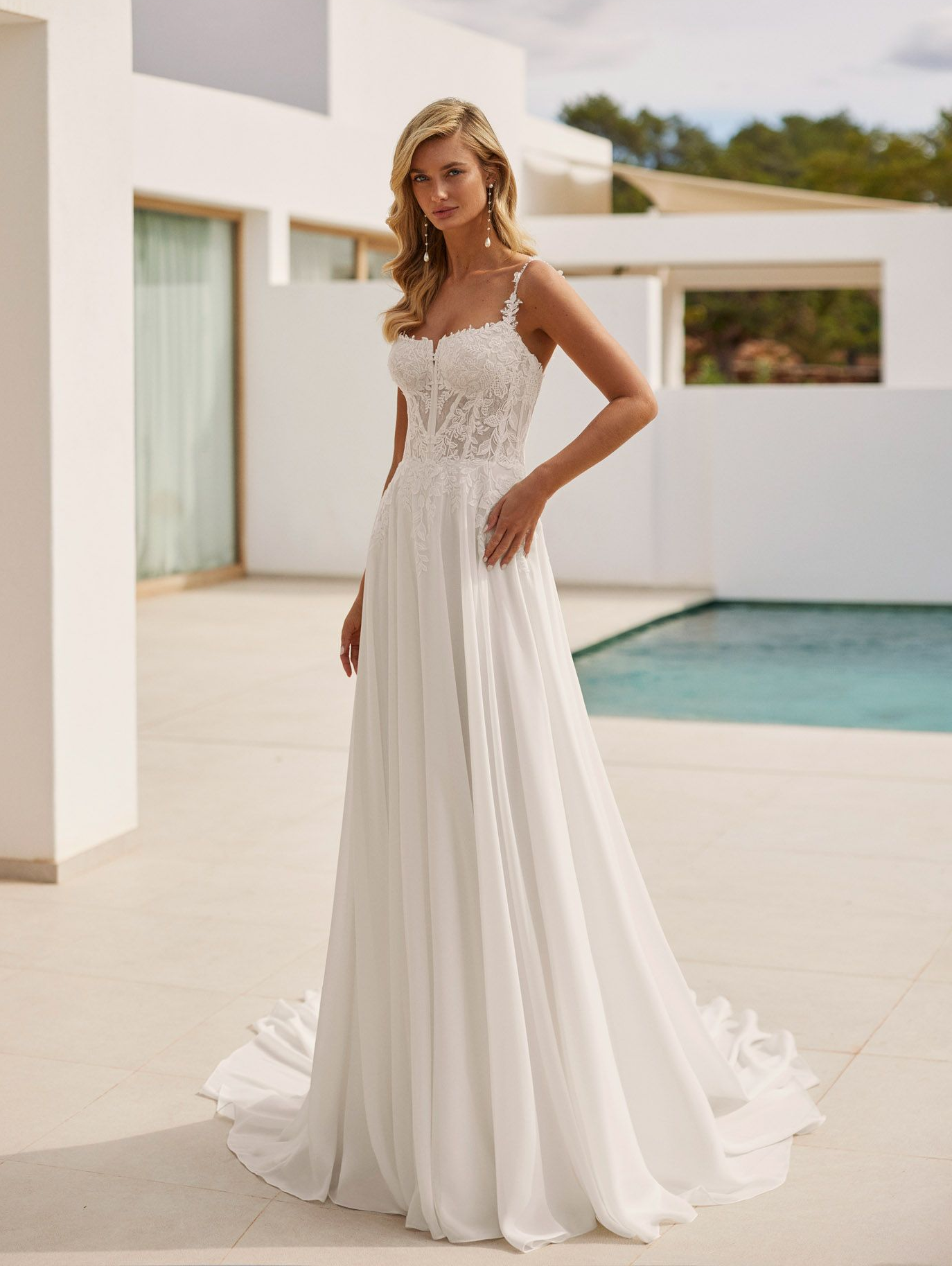 Langes ausgestelltes Brautkleid aus Georgette mit Spitzenoberteil, Perlen, herzförmigem Ausschnitt, Blumen-Trägern und Korsettrücken.