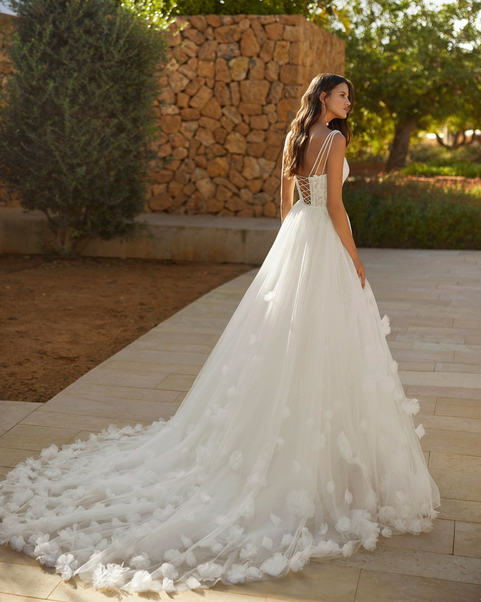 Eine Frau in einem Brautkleid steht vor einem Pool.