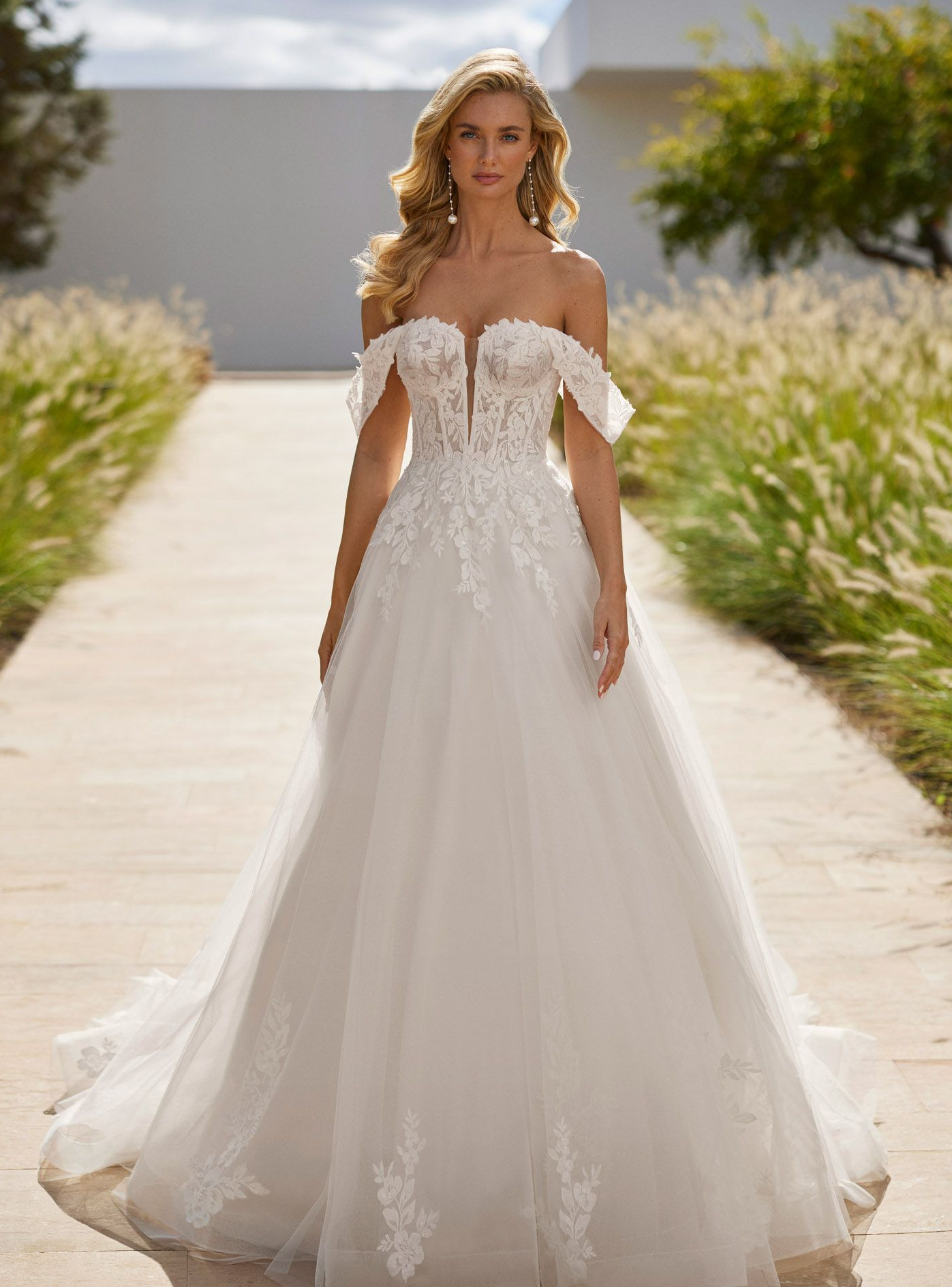 Langes voluminöses Brautkleid aus Tüll mit Spitzenoberteil, Perlen, tiefem Ausschnitt, abnehmbaren Trägern und Korsettrücken.