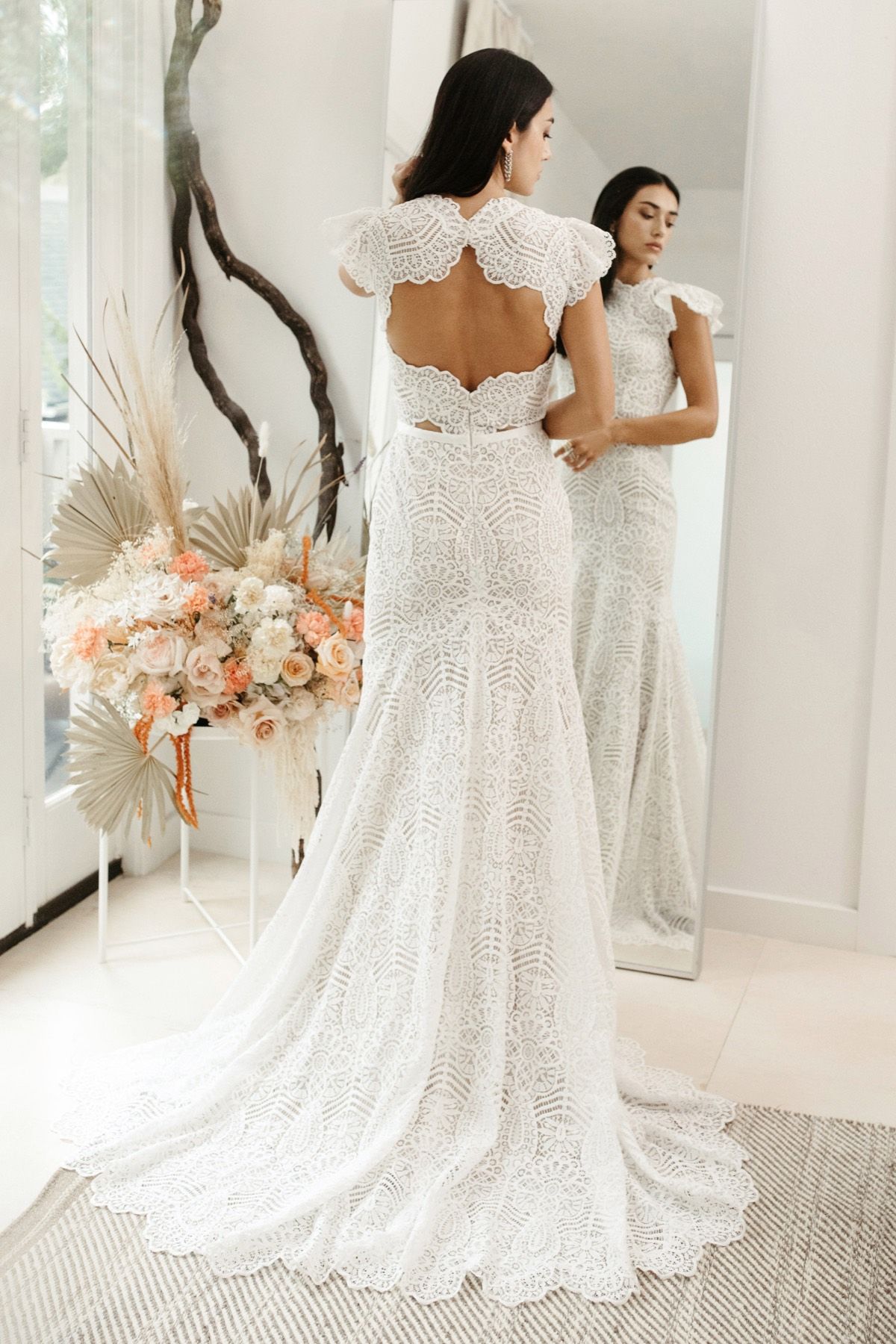 Eine Frau in einem Brautkleid steht auf einer Treppe vor einem Gebäude.