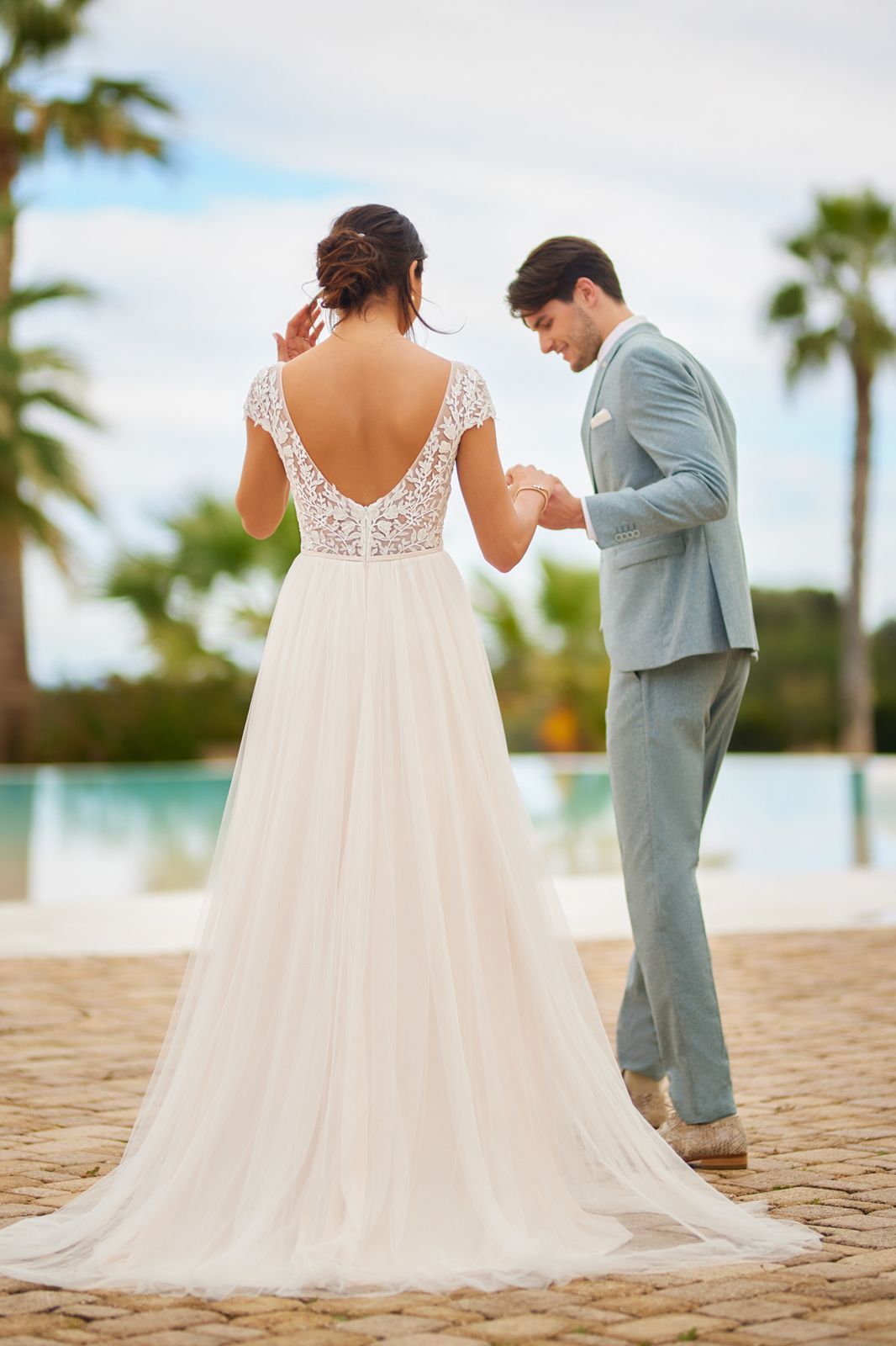 Eine Frau in einem Brautkleid steht vor einem Fenster.