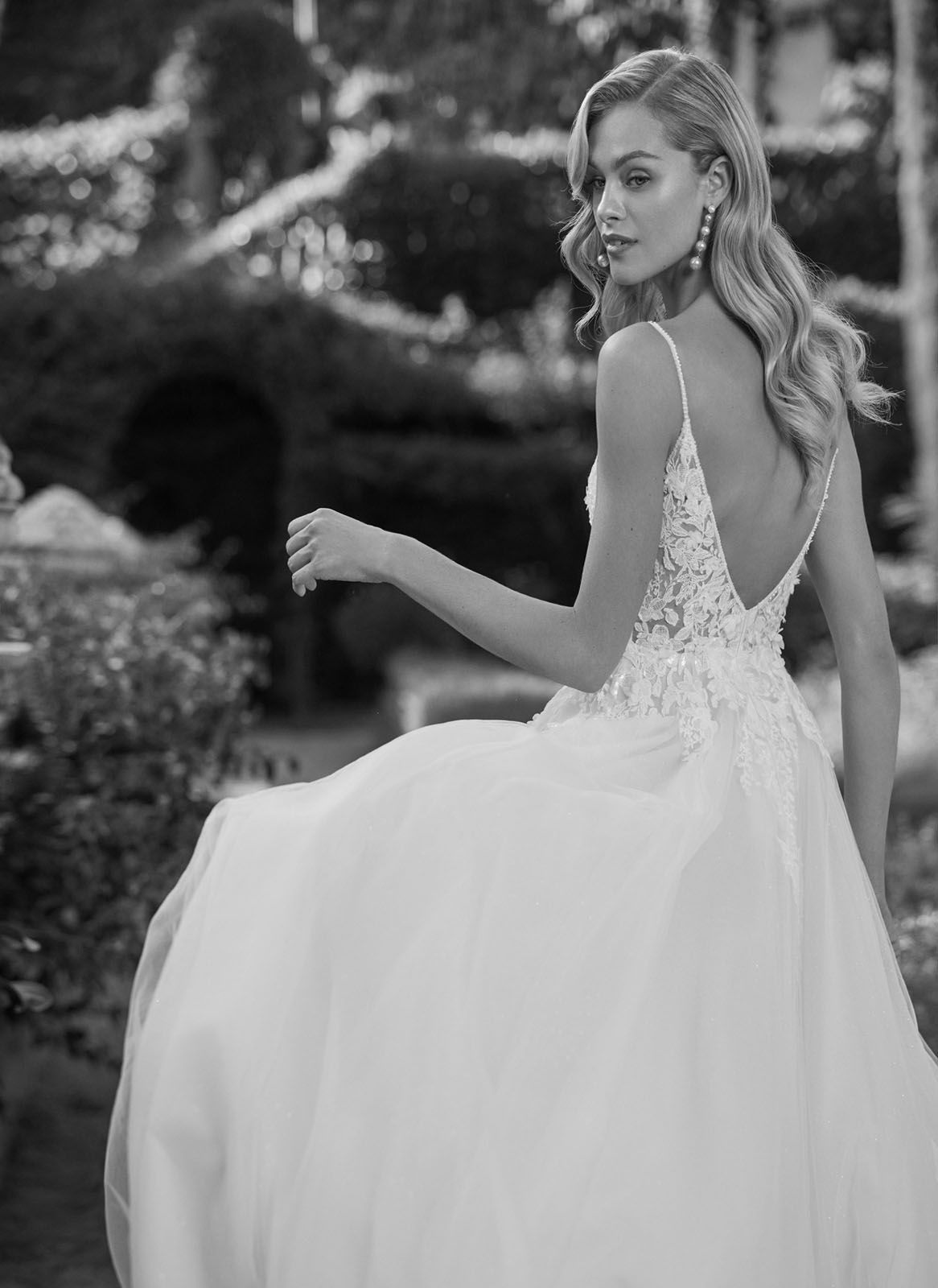 Eine Frau in einem Brautkleid steht auf einer Treppe vor einem Gebäude.