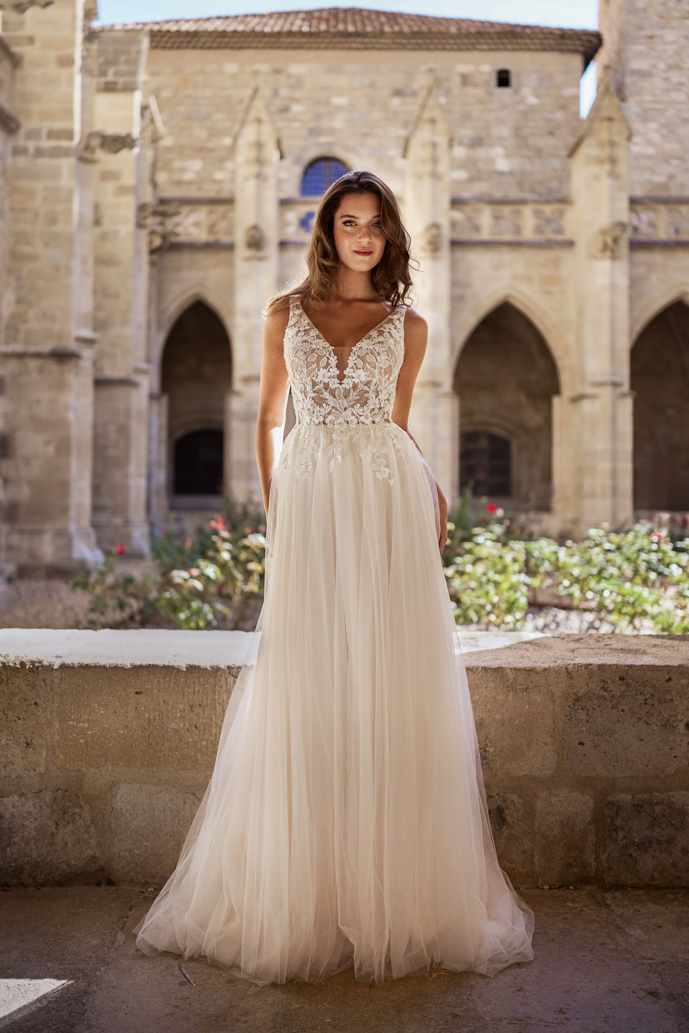 Eine Frau in einem Brautkleid steht in der Wüste.