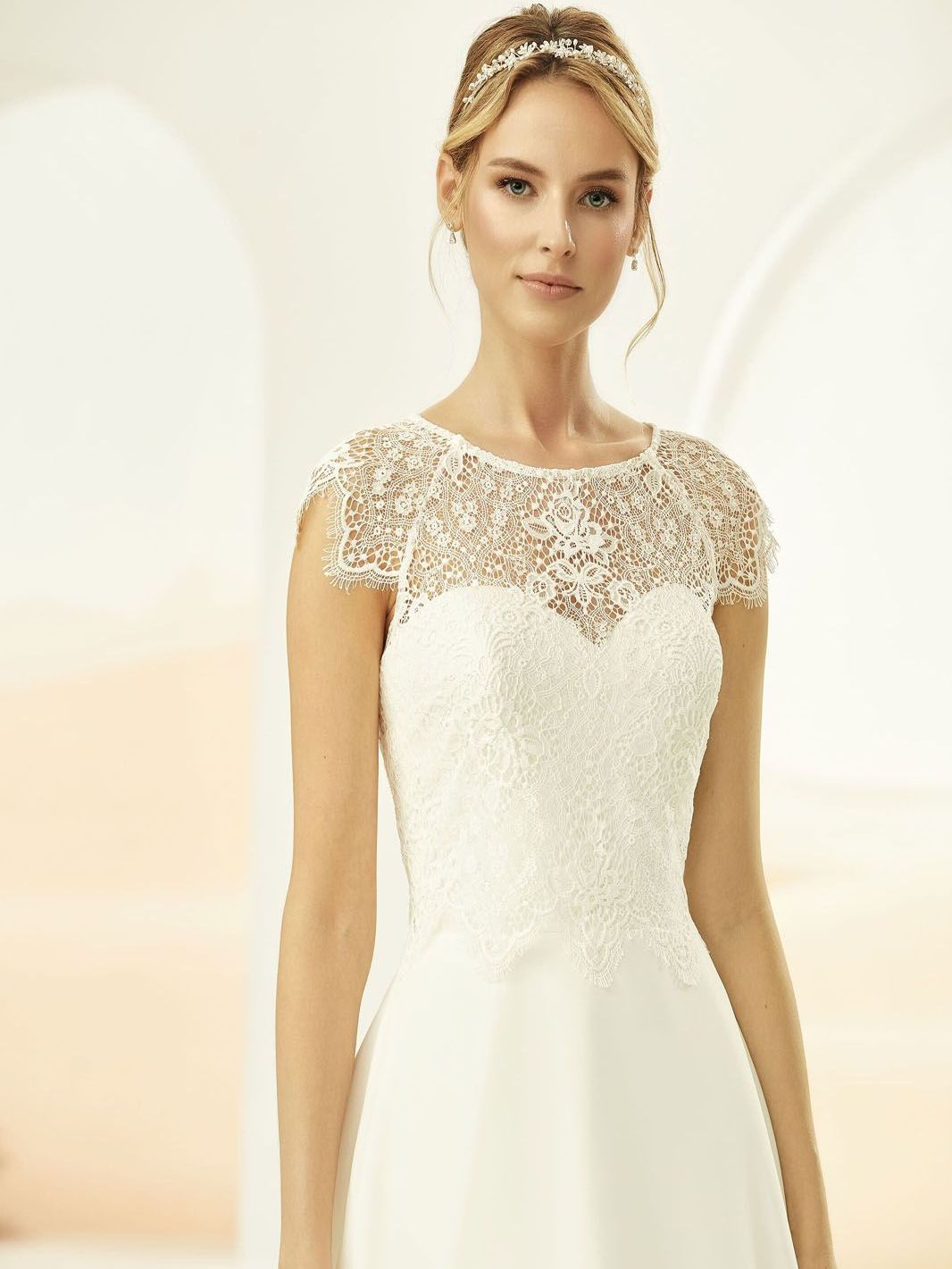 Eine Frau in einem weißen Brautkleid steht in einem Raum.