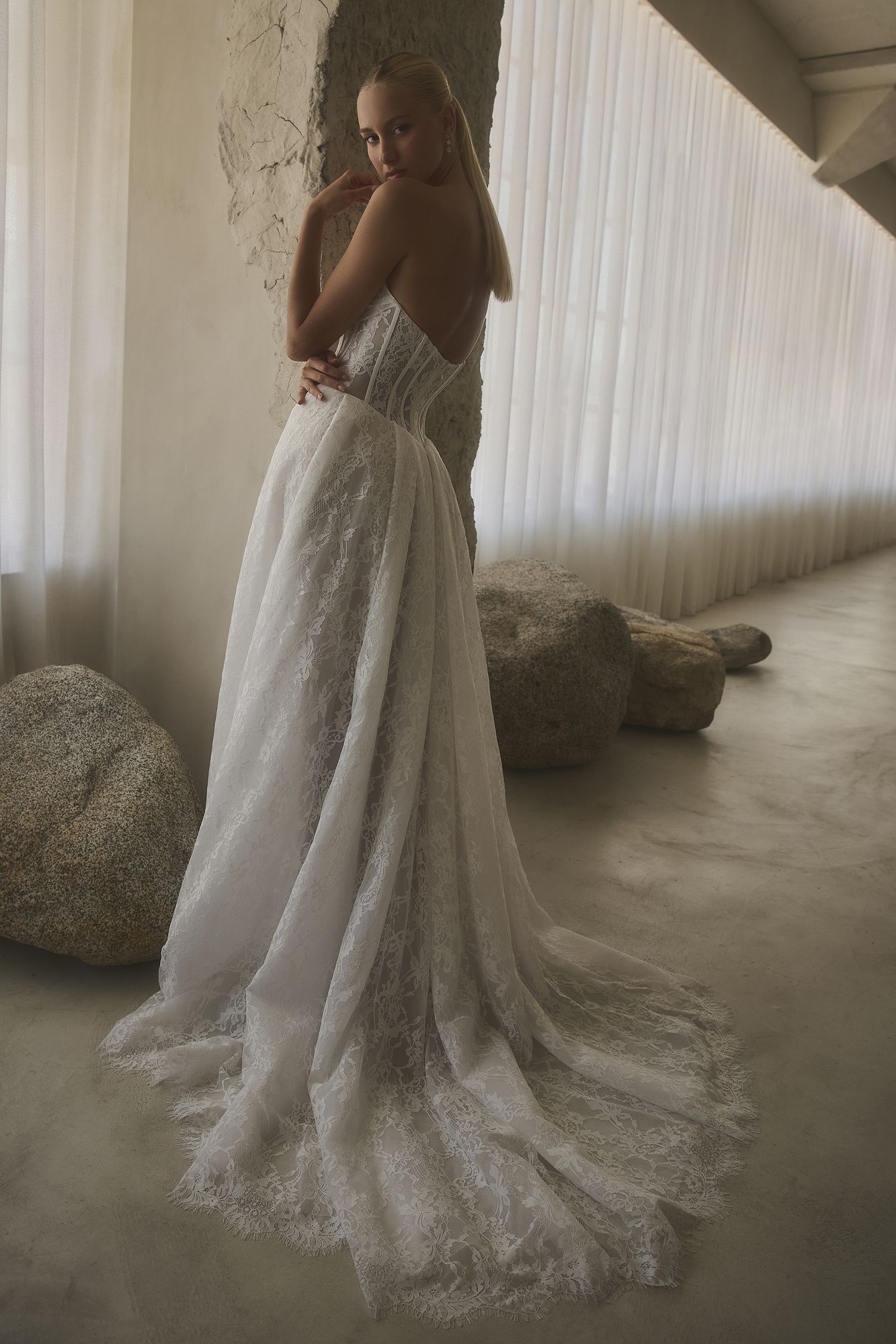 Eine Frau in einem Brautkleid steht in der Wüste.