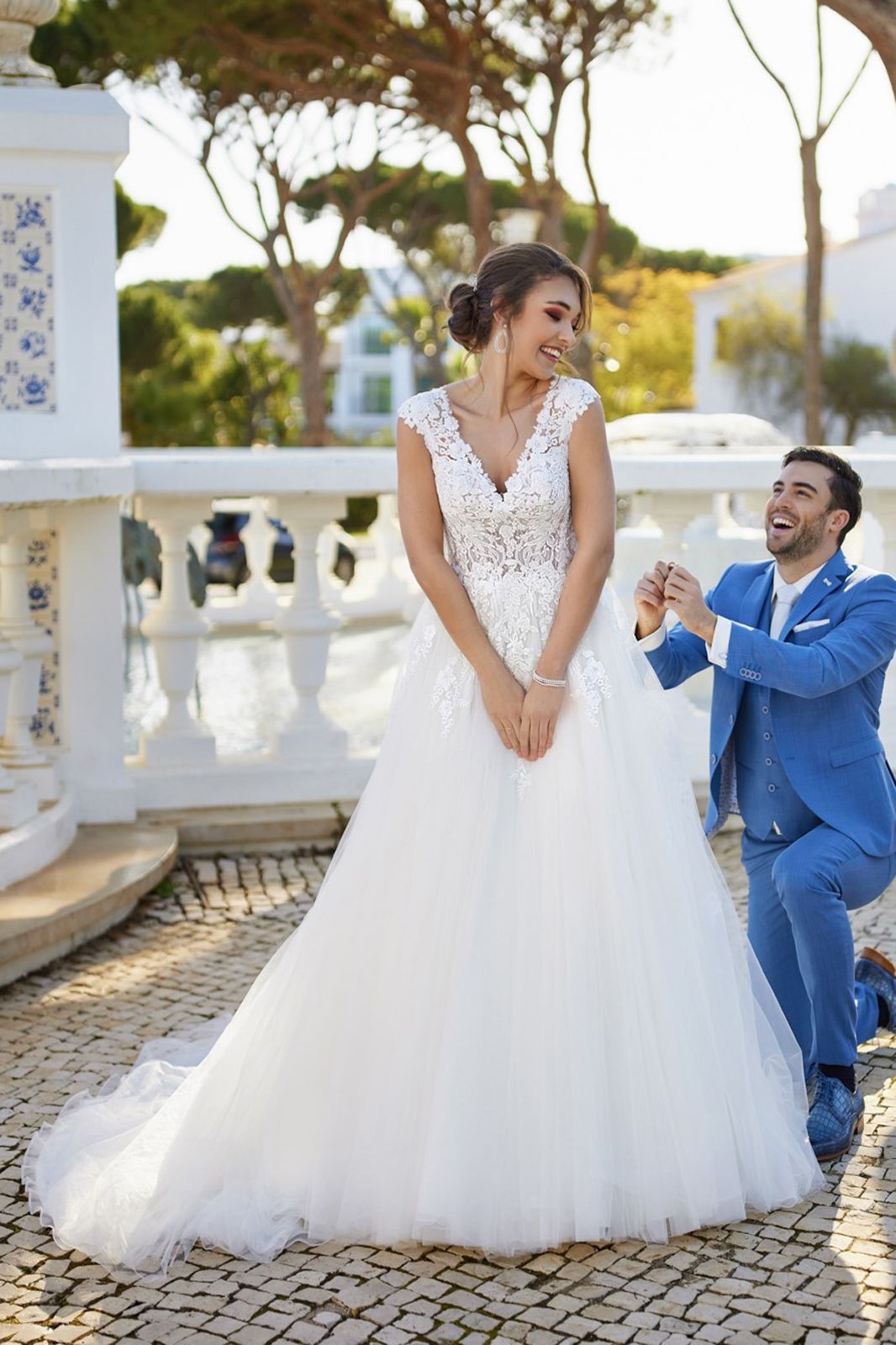 Eine Frau in einem Brautkleid steht in einem Raum mit vielen Fenstern.