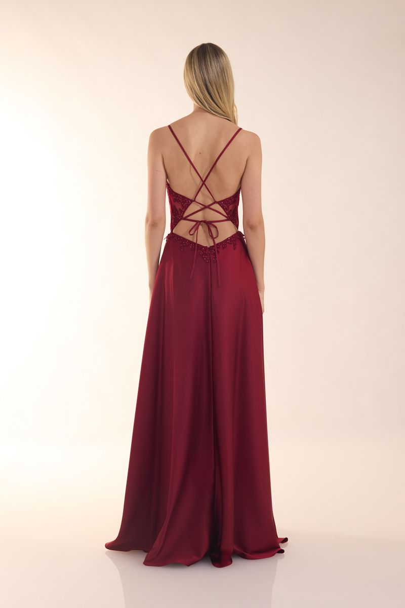 Eine Frau in einem grünen Kleid steht vor einer Holztür.