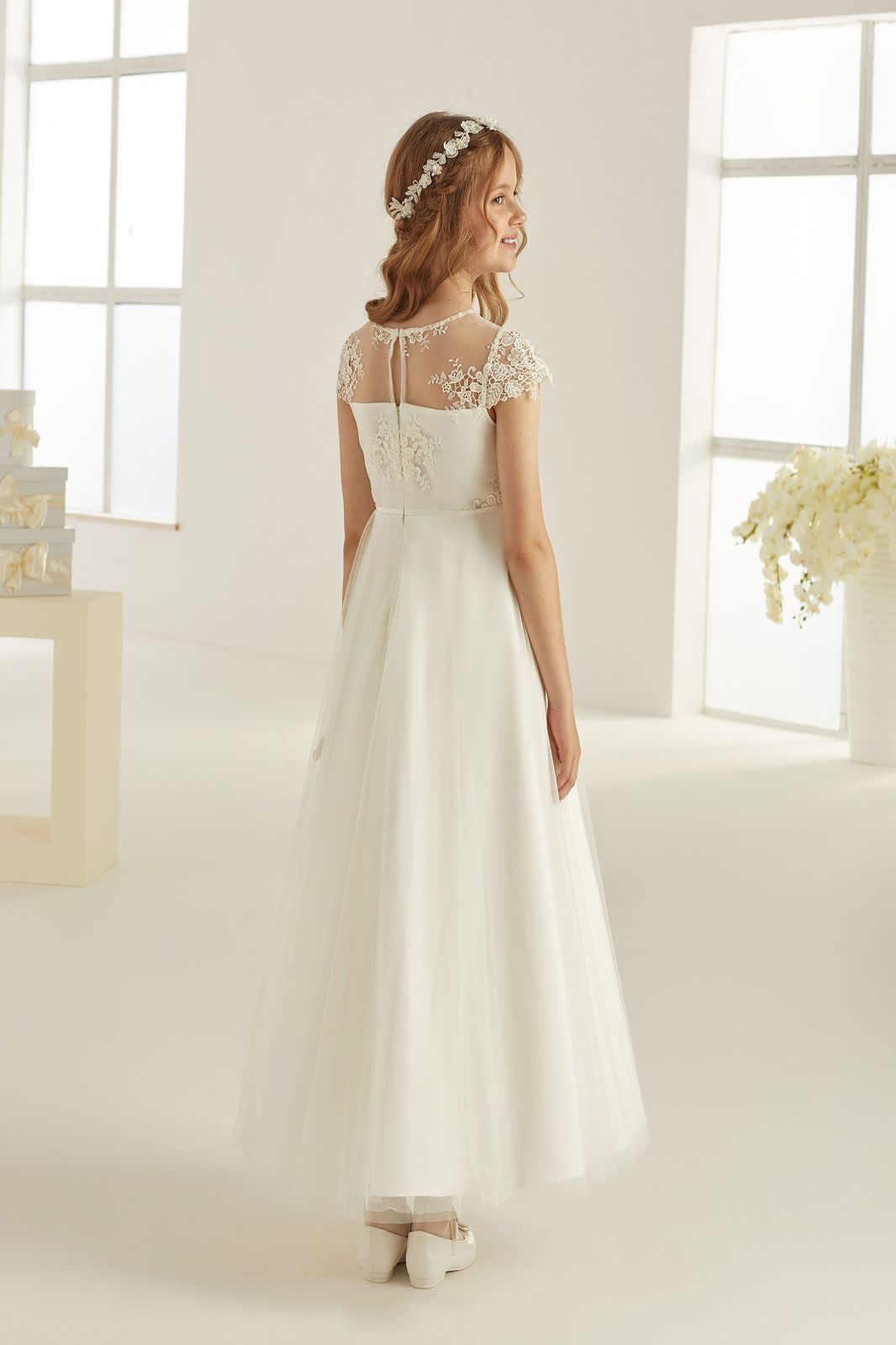 Eine Frau in einem weißen Kleid steht in einem Raum.