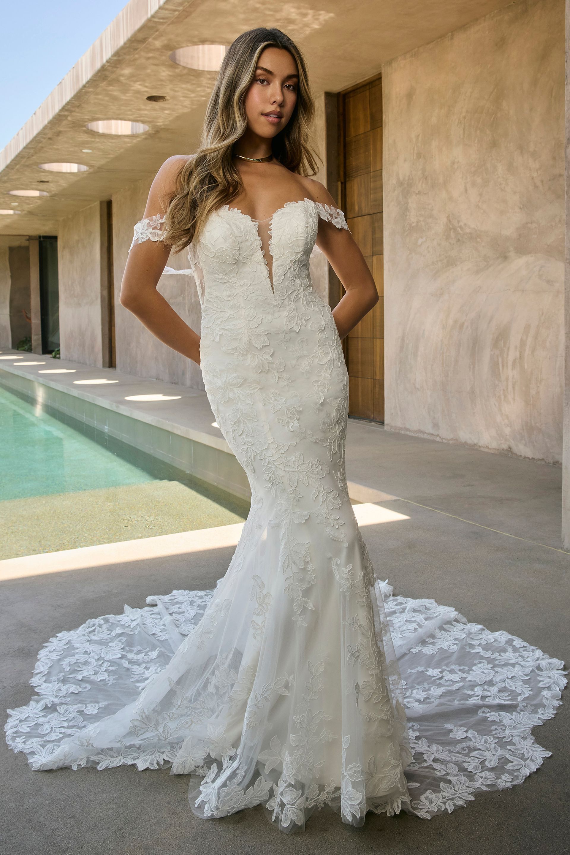Eine Frau in einem Brautkleid steht in der Wüste.