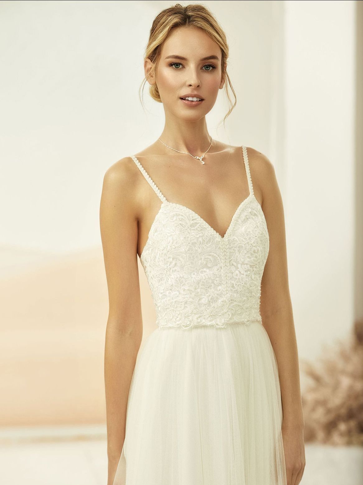 Eine Frau in einem weißen Brautkleid steht in einem Raum.