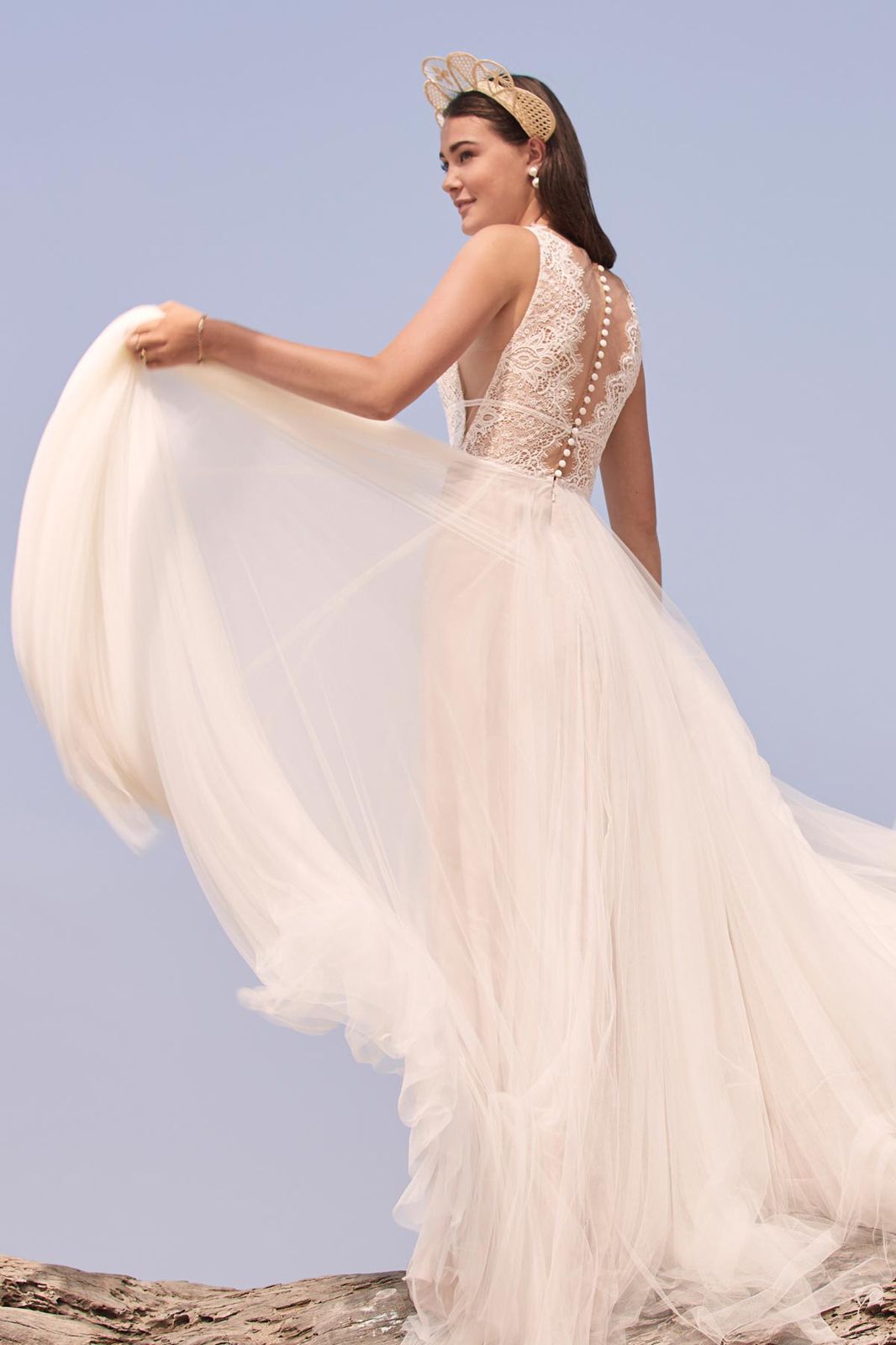 Eine Frau in einem Brautkleid steht auf einer Treppe vor einem Gebäude.