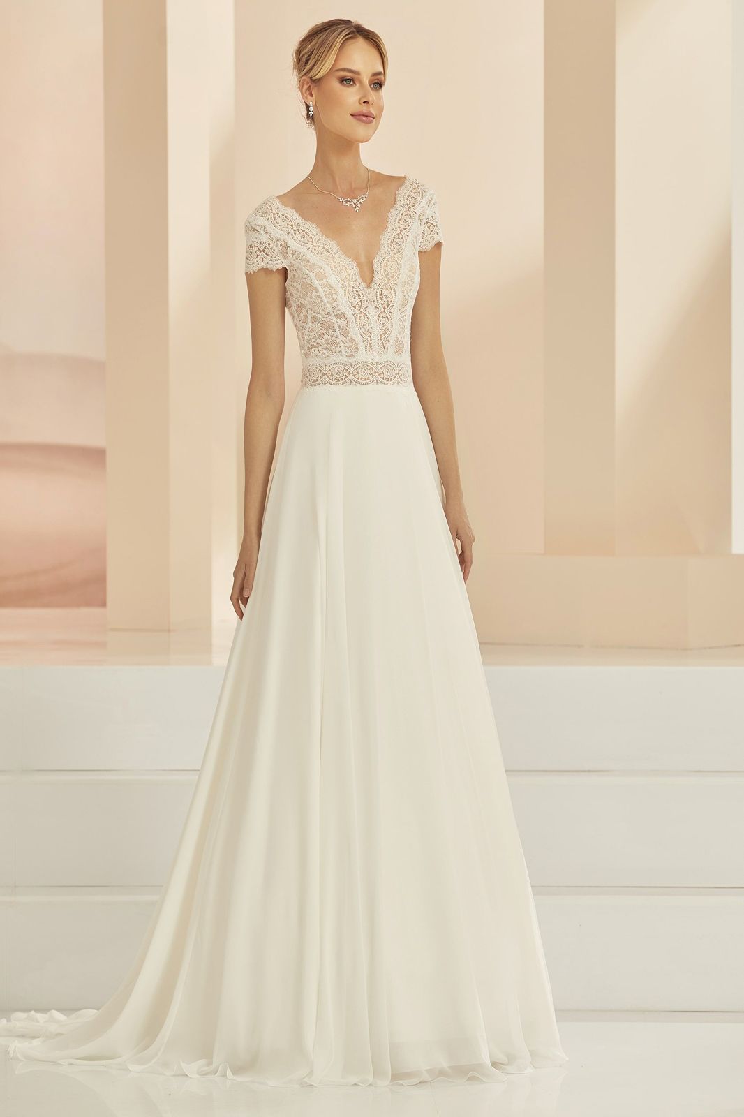 Eine Frau in einem Brautkleid steht in der Wüste.