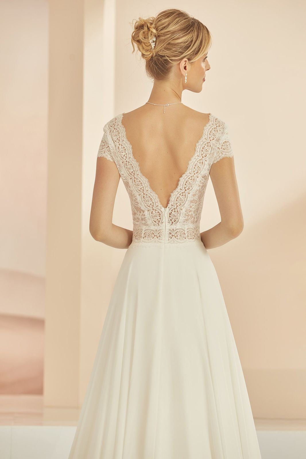 Eine Frau in einem Brautkleid steht in der Wüste.