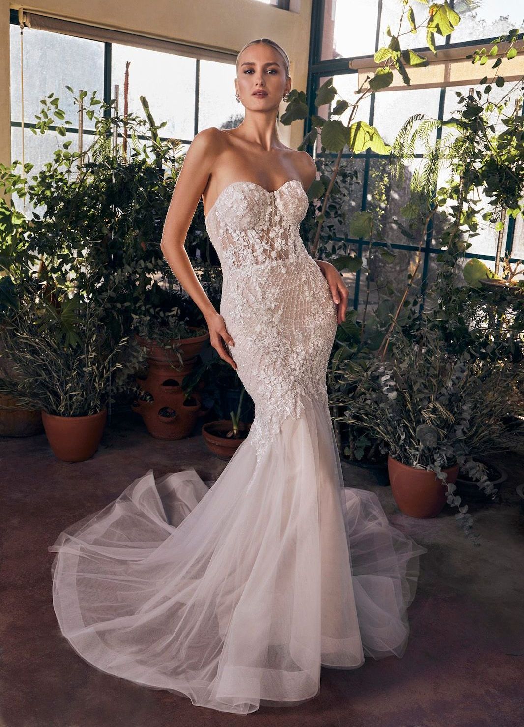 Eine Frau in einem weißen Brautkleid steht auf einer Holzbrücke.