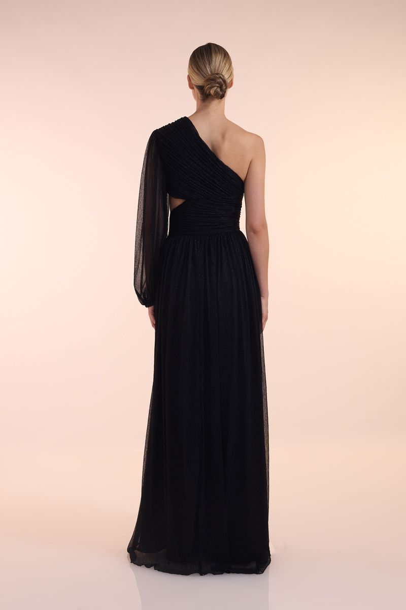 Eine Frau in einem grünen Kleid steht vor einer Holztür.