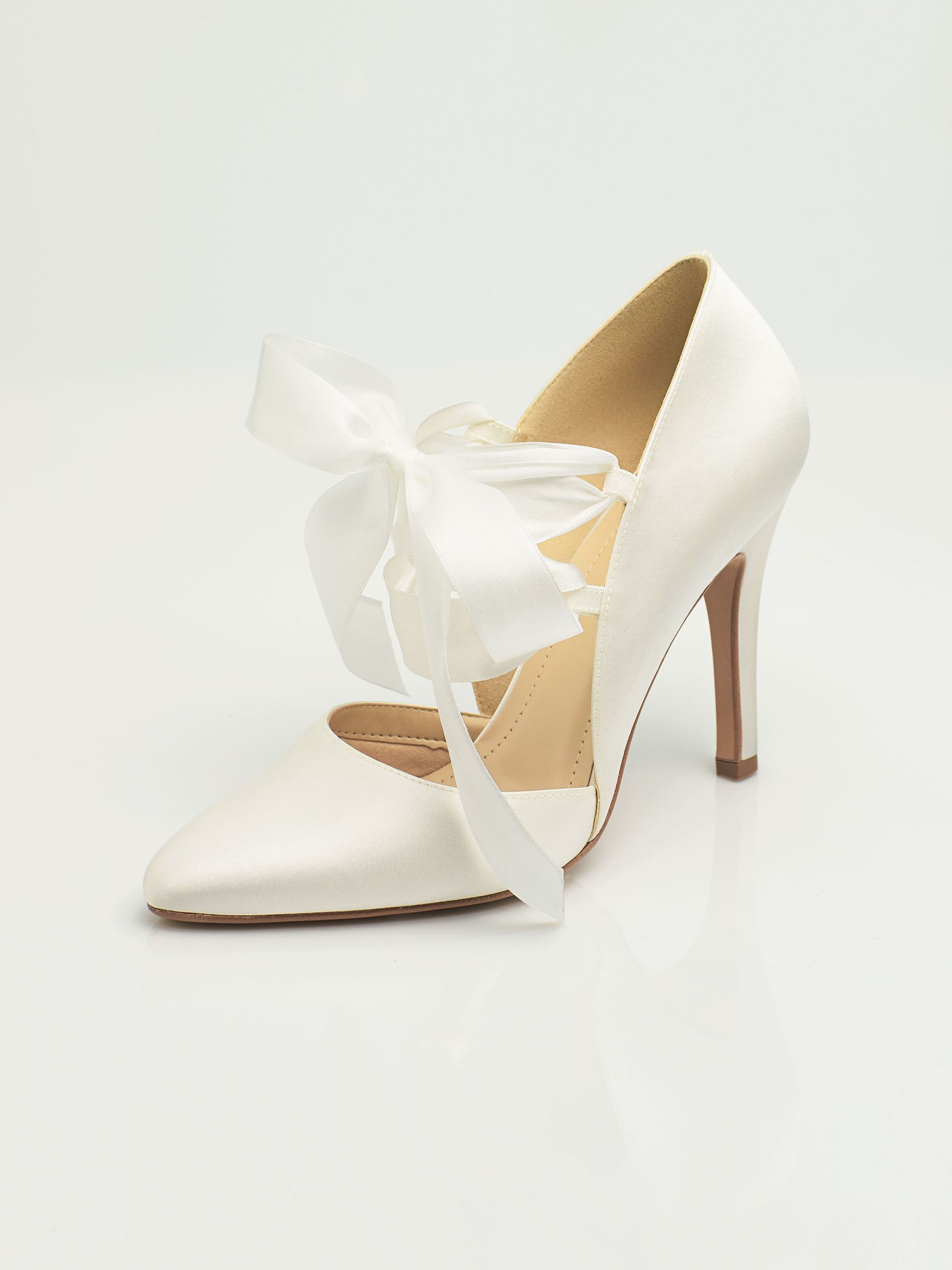 Ein Paar weiße Schuhe mit einer Schleife an der Seite