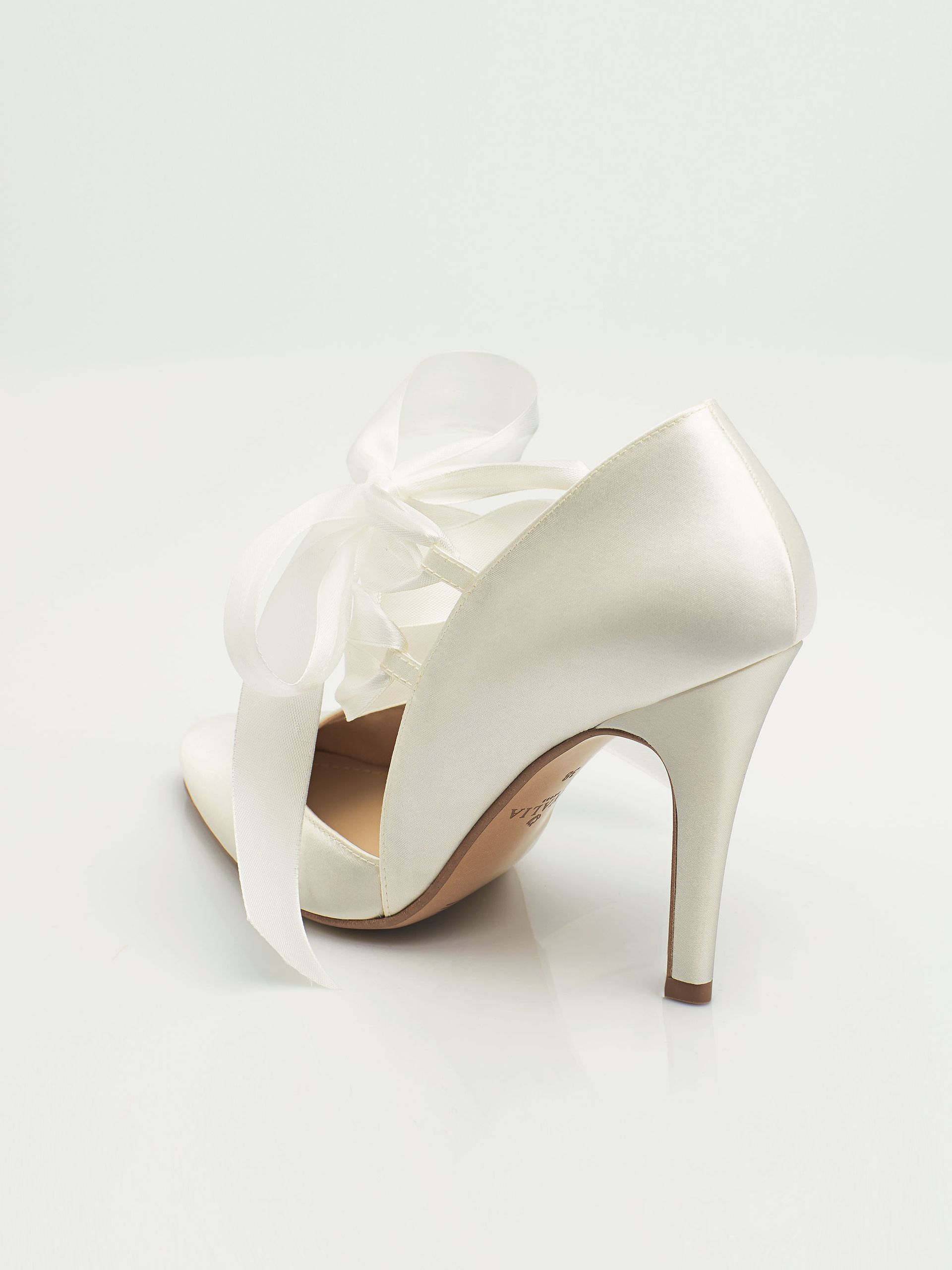 Ein Paar weiße Schuhe mit einer Schleife an der Seite