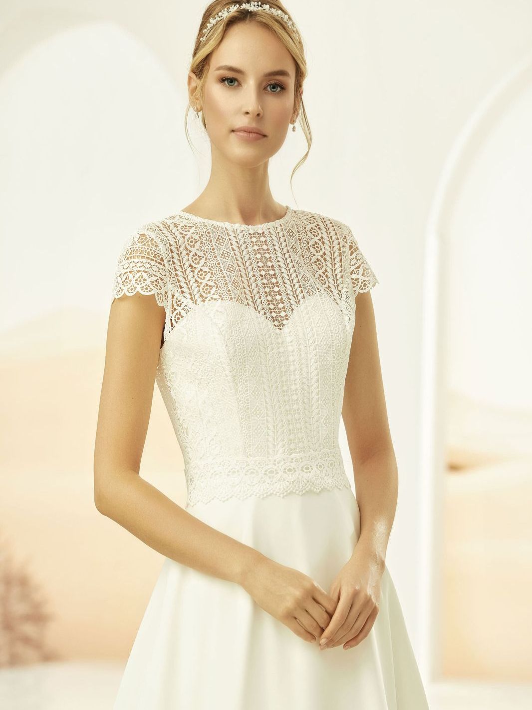 Eine Frau in einem weißen Brautkleid steht in einem Raum.