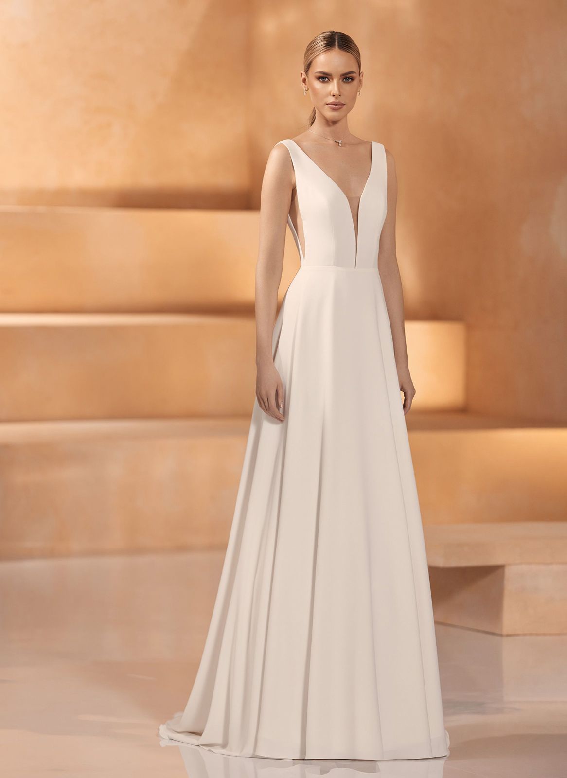 Eine Frau in einem weißen Brautkleid steht vor einem Gebäude.