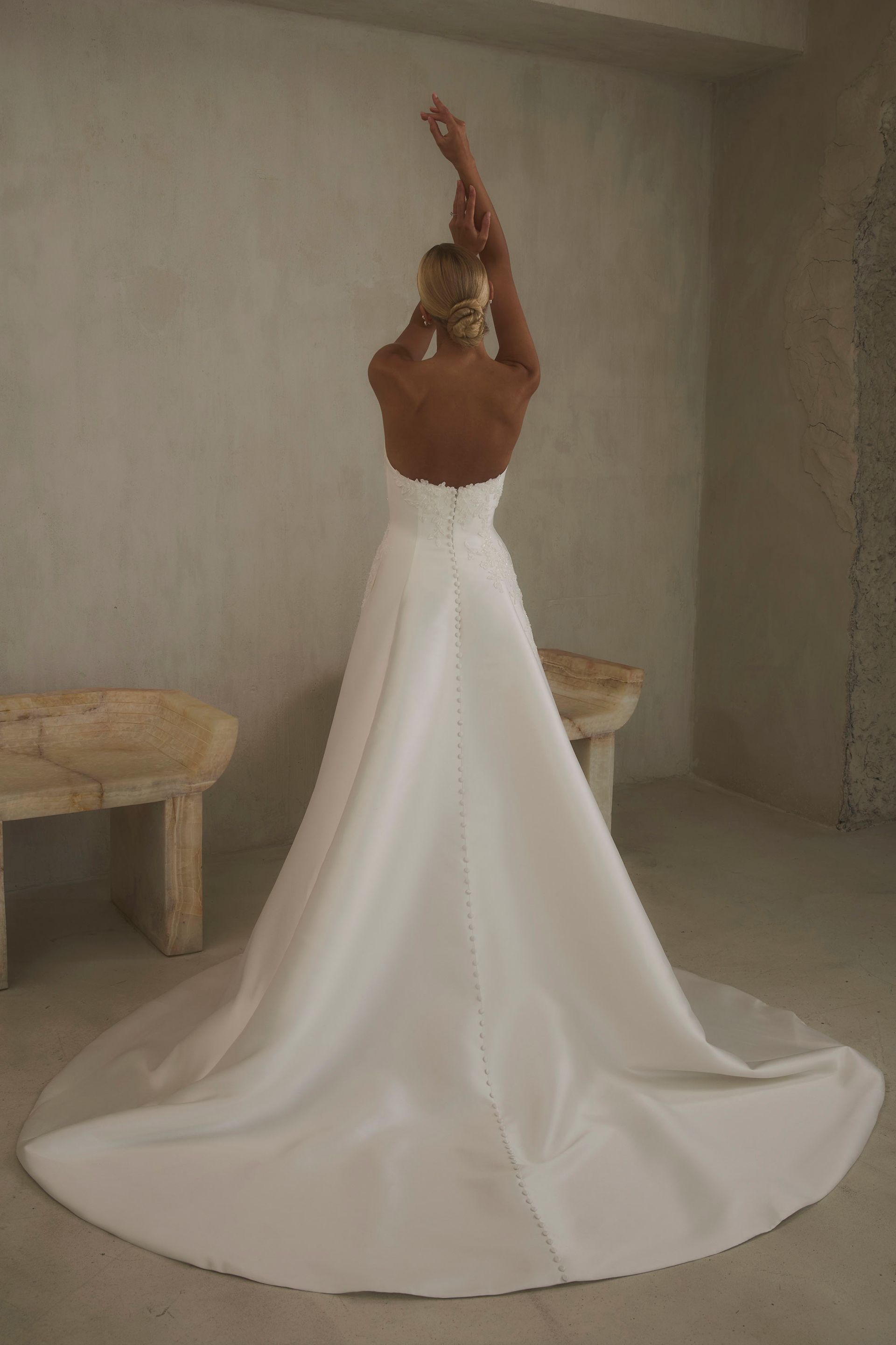 Eine Frau in einem Brautkleid steht in der Wüste.