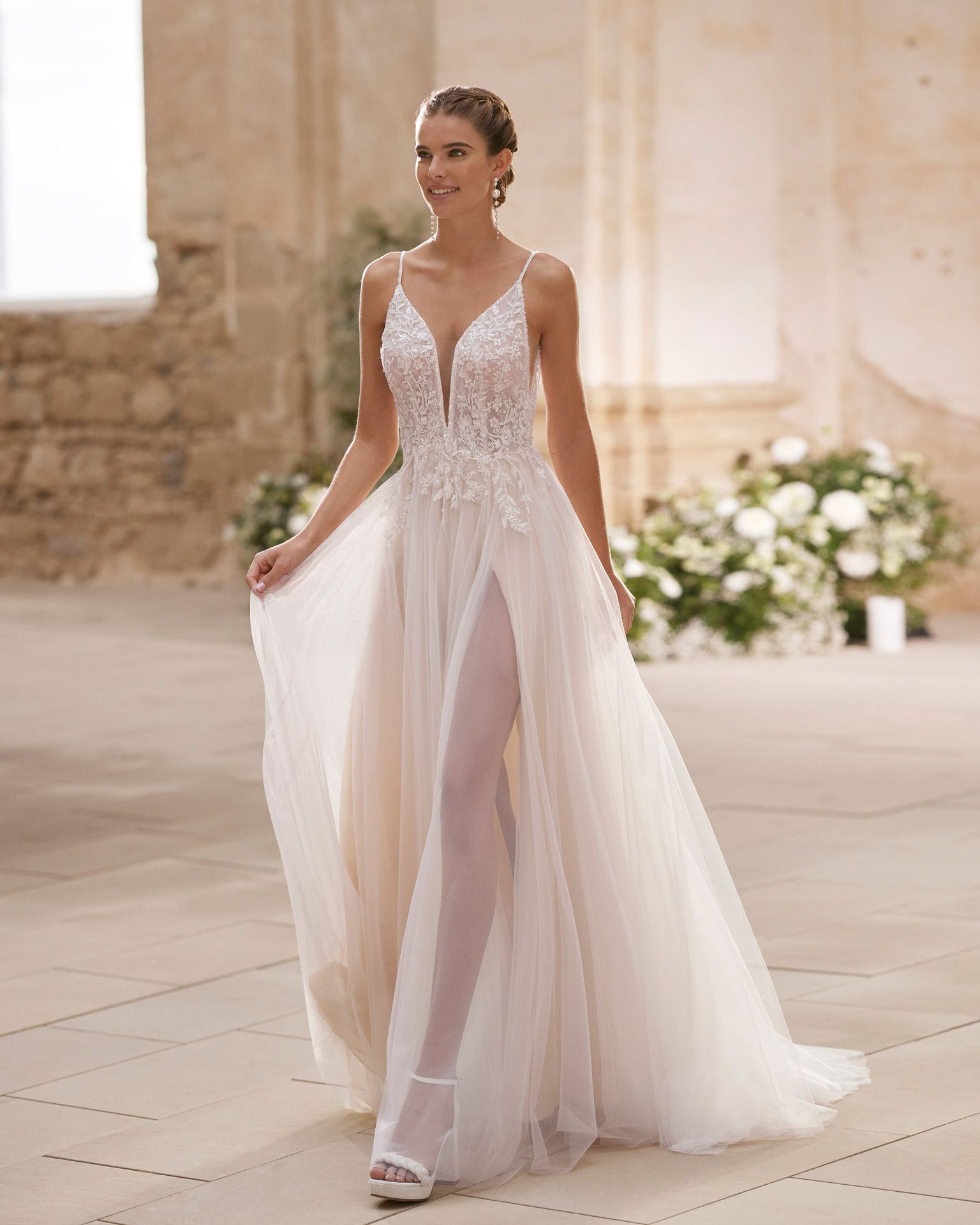 Eine Frau in einem weißen Brautkleid steht vor einem Gebäude.
