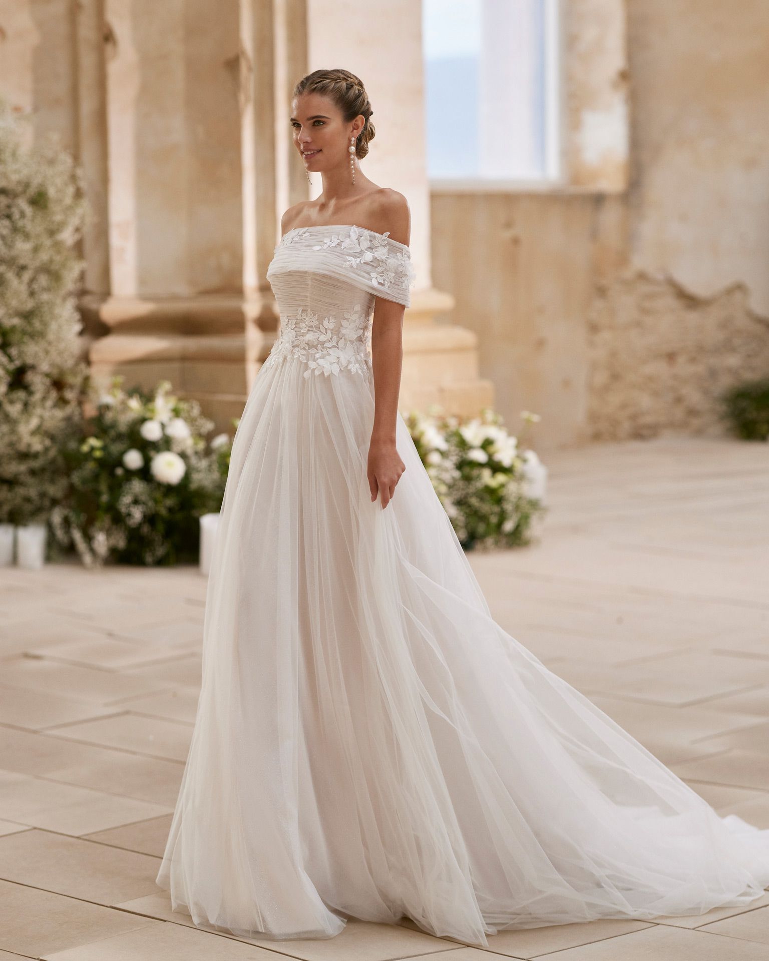 Eine Frau in einem weißen Brautkleid steht vor einem Gebäude.
