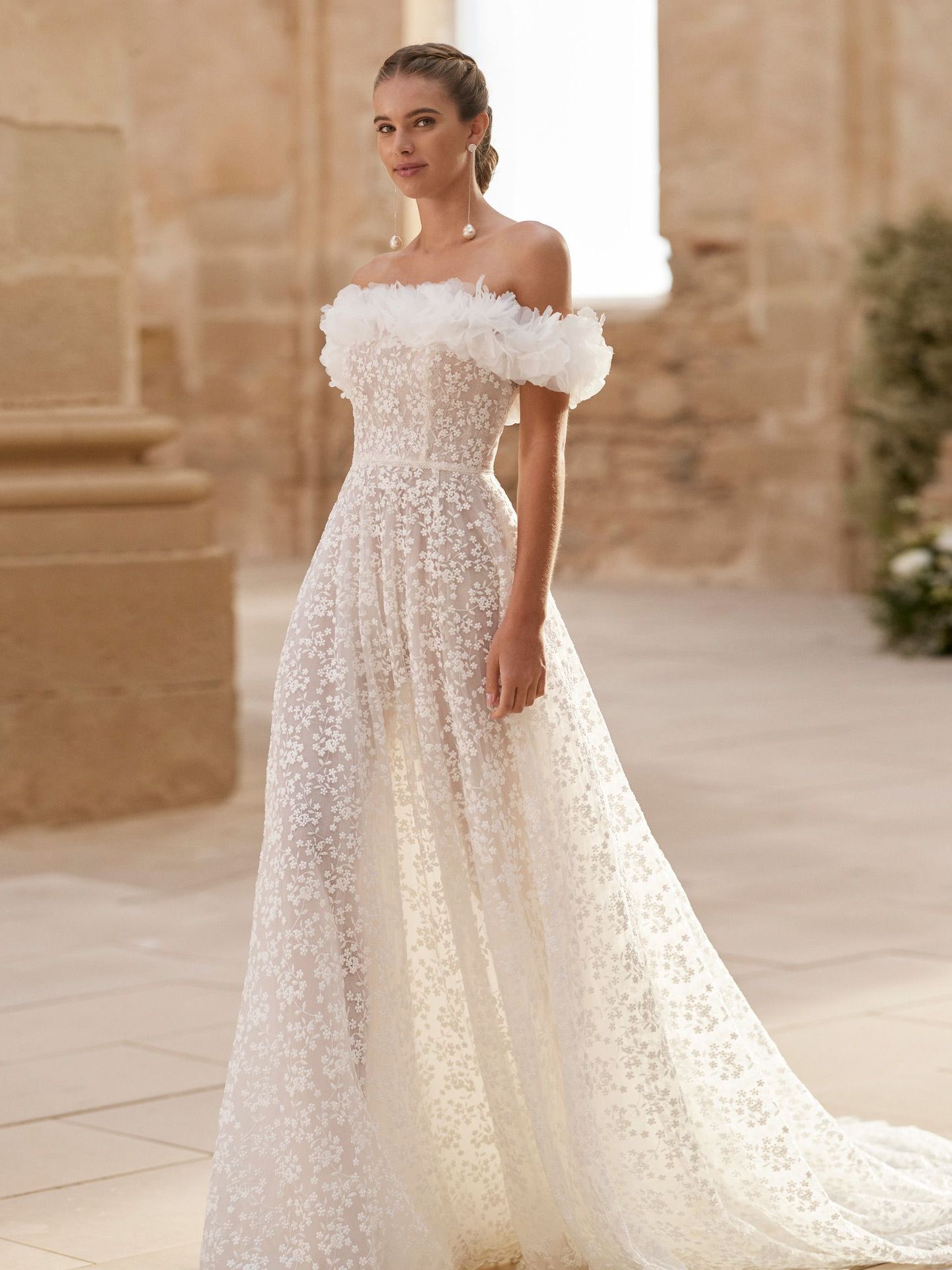 Eine Frau in einem weißen Brautkleid steht vor einem Gebäude.