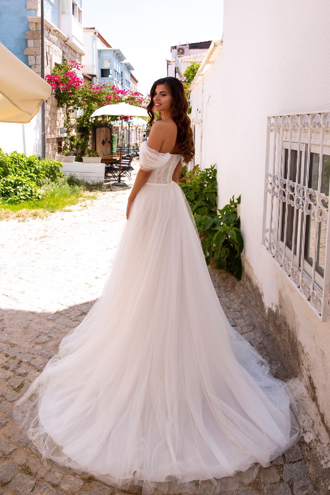 Eine Frau in einem Brautkleid steht auf einer Treppe vor einem Gebäude.
