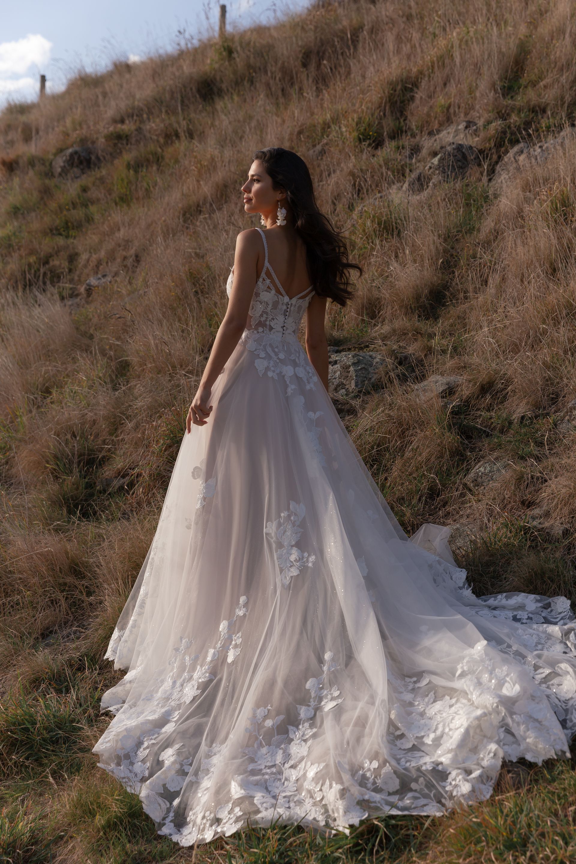 Eine Frau in einem Brautkleid steht in der Wüste.
