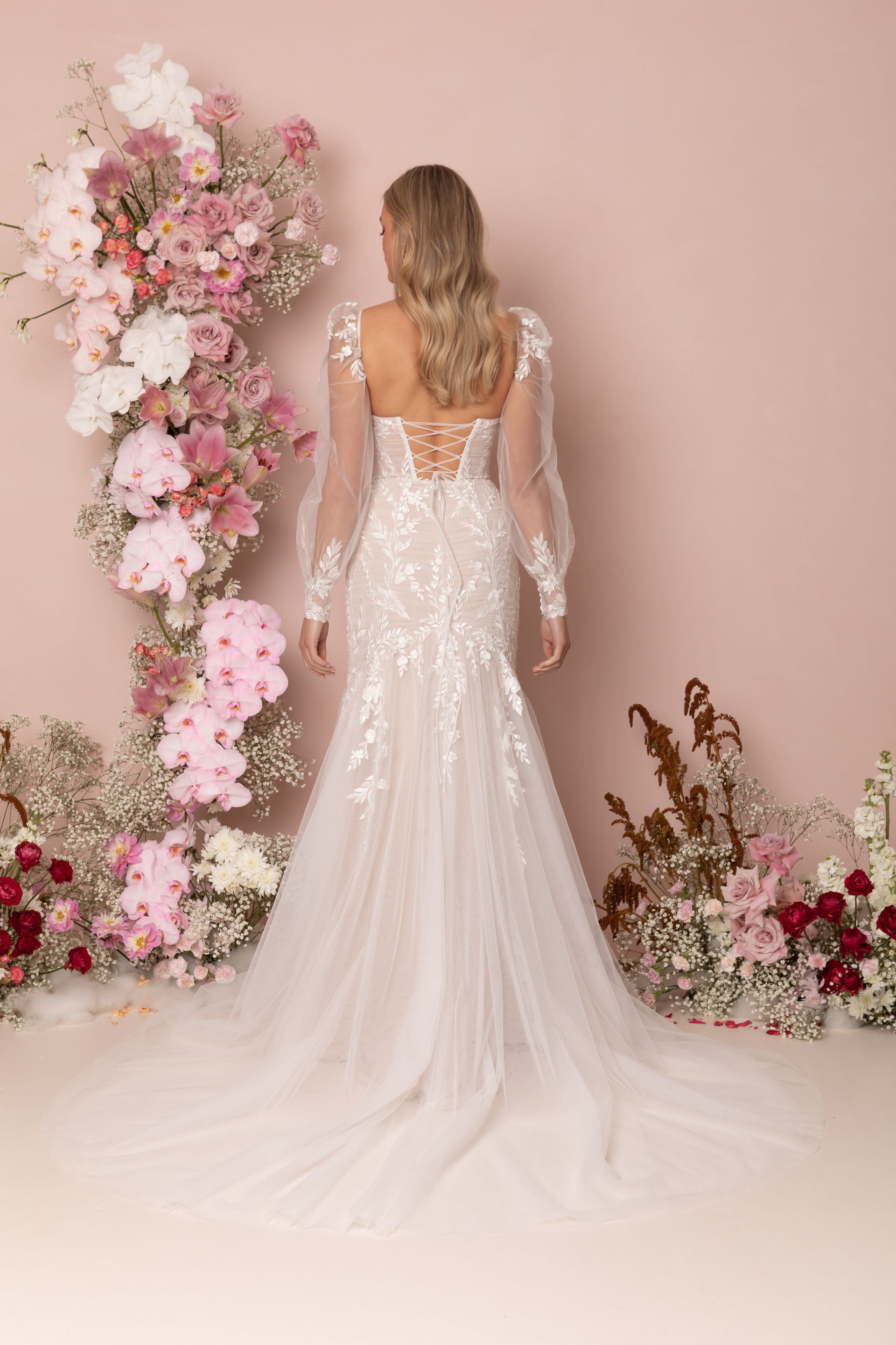 Eine Frau in einem Brautkleid steht in der Wüste.