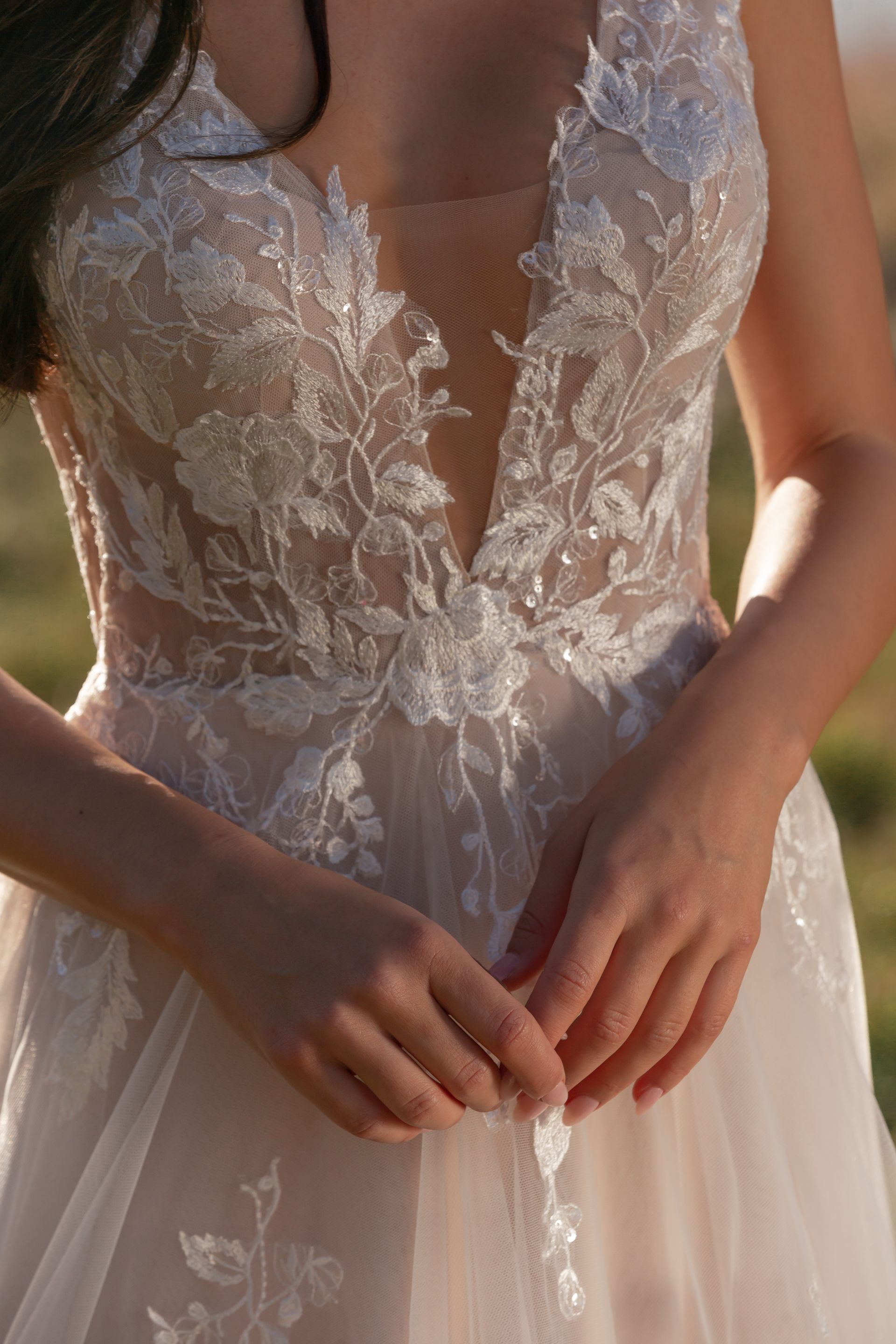 Eine Frau in einem Brautkleid steht an einem steinigen Strand.