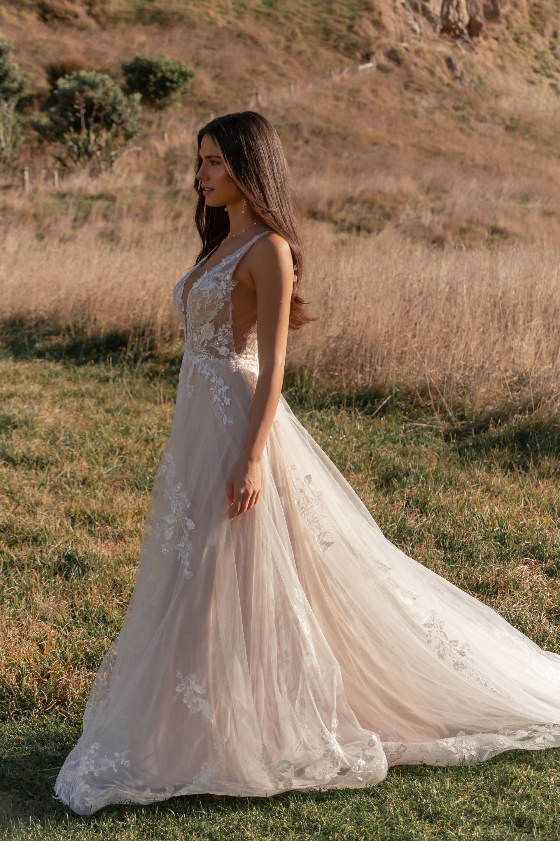 Eine Frau in einem Brautkleid steht in der Wüste.