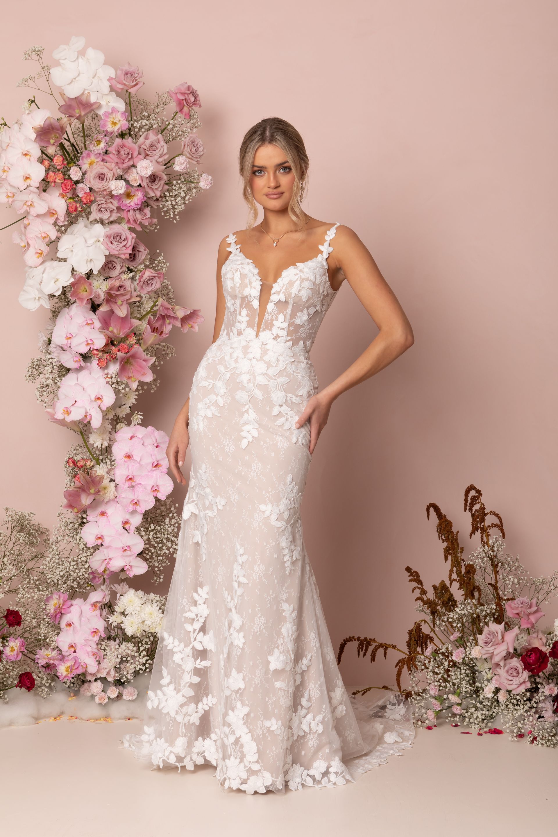 Eine Frau in einem Brautkleid steht in der Wüste.