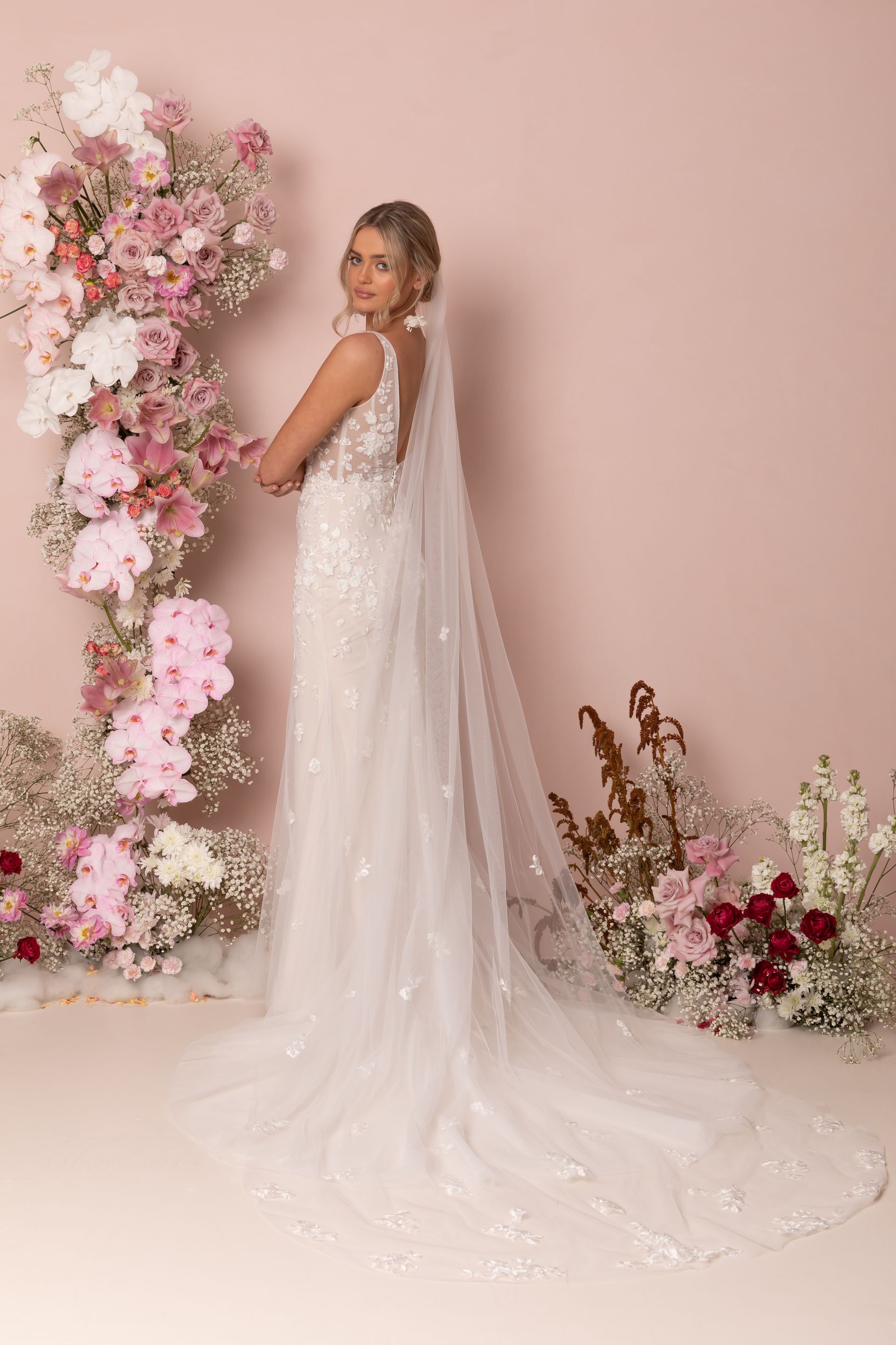 Eine Frau in einem Brautkleid steht in der Wüste.