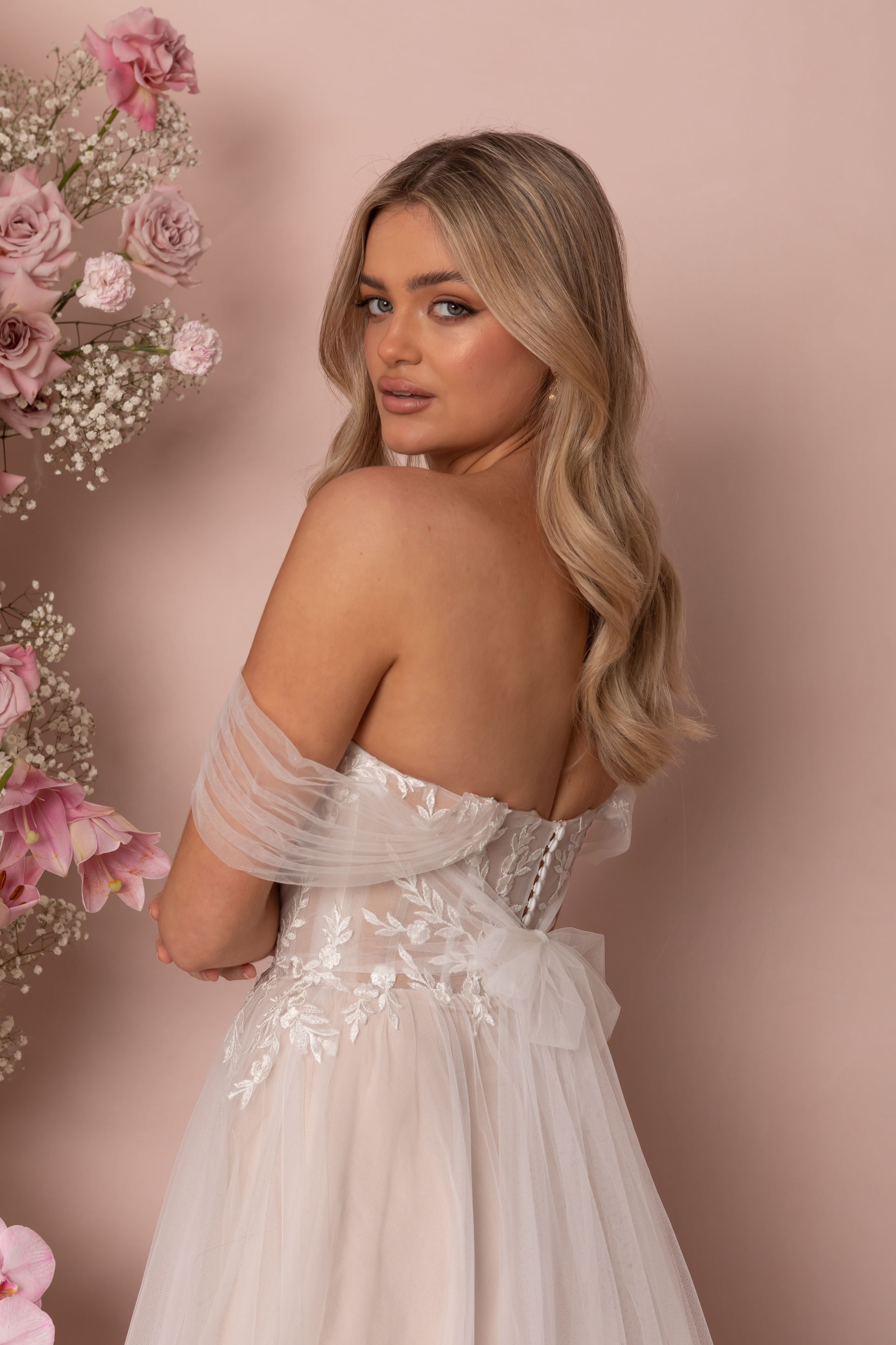 Eine Frau in einem Brautkleid steht in der Wüste.