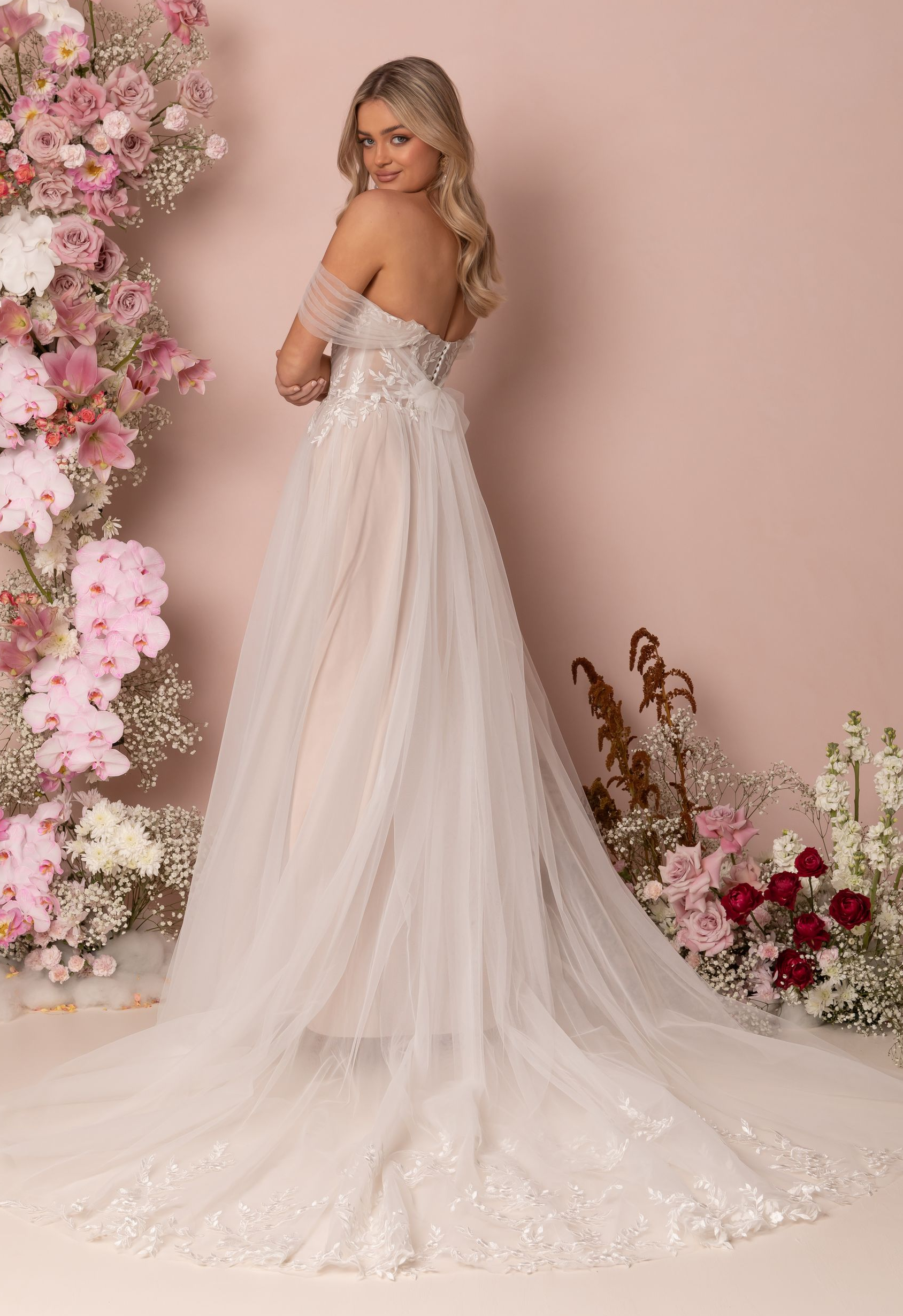 Eine Frau in einem Brautkleid steht in der Wüste.