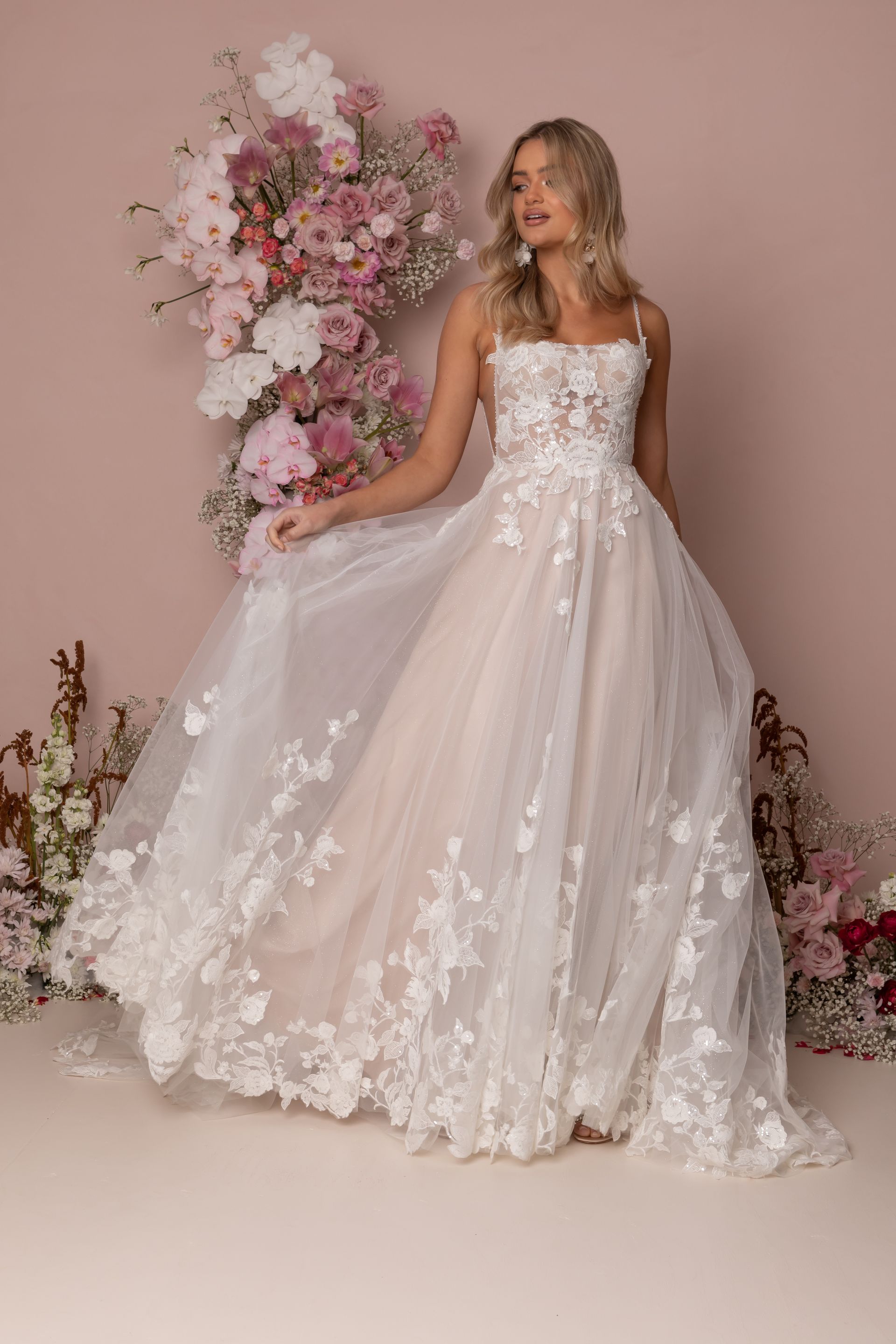 Eine Frau in einem Brautkleid steht in der Wüste.