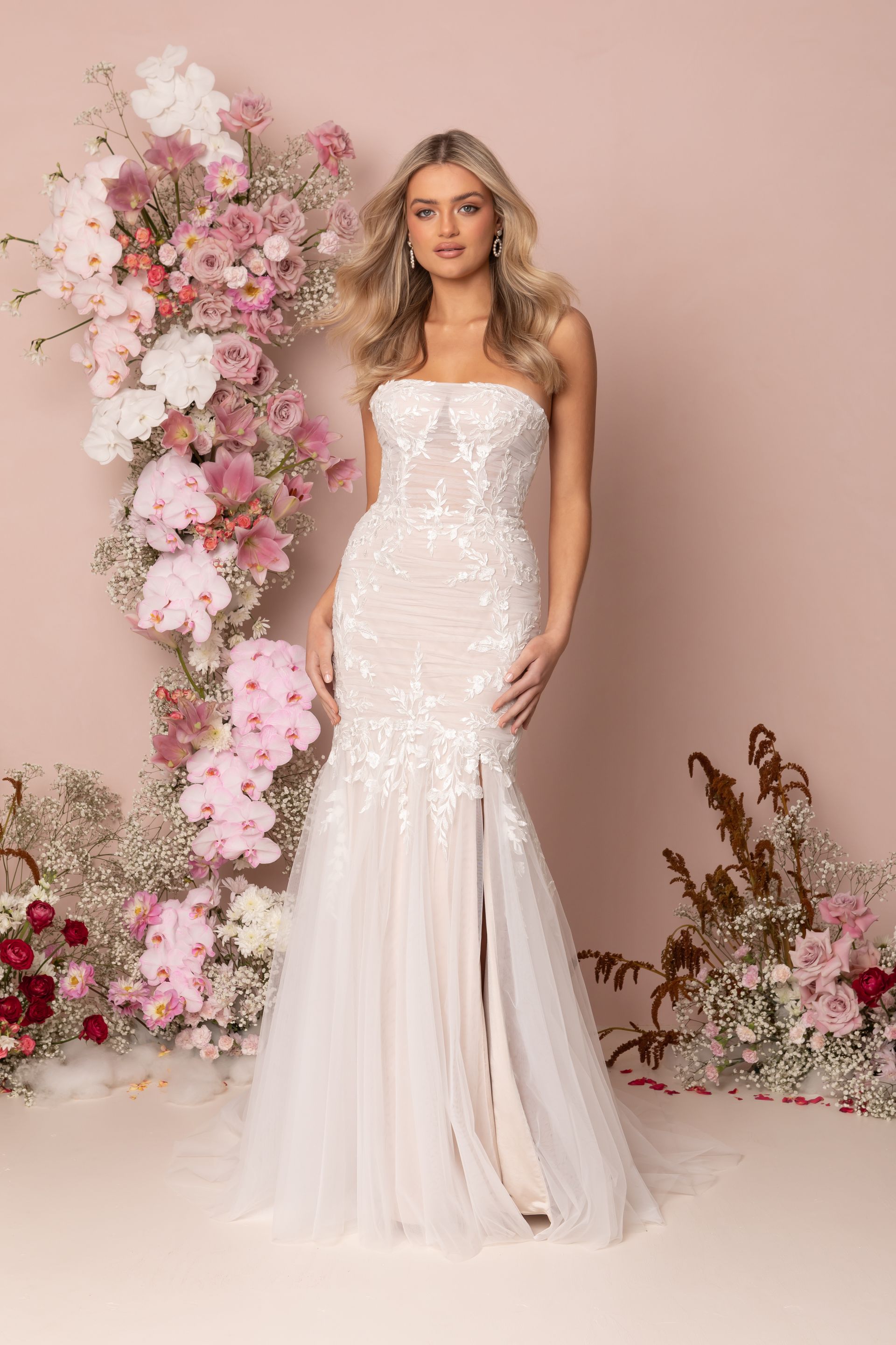 Eine Frau in einem Brautkleid steht in der Wüste.