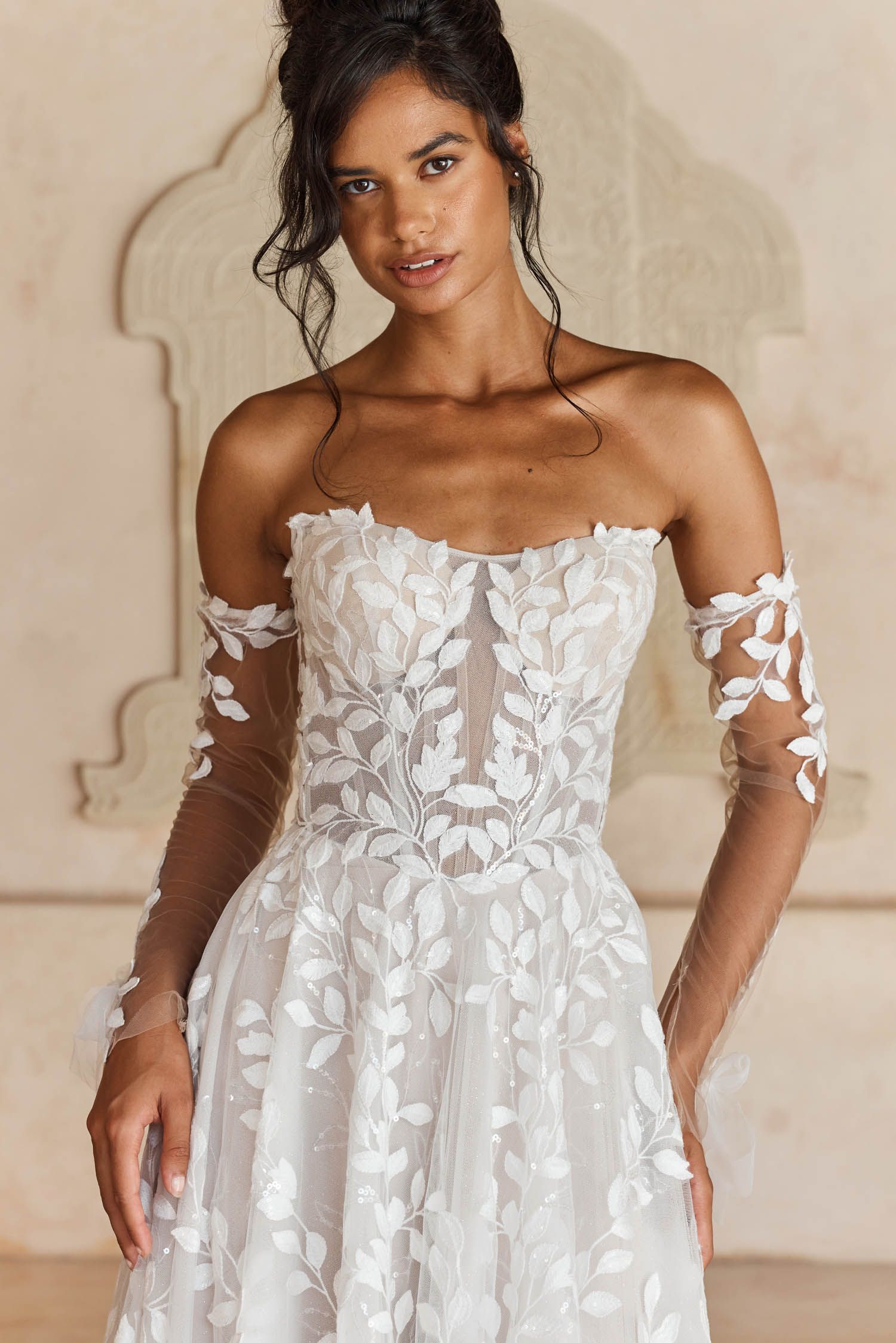 Eine Frau in einem Brautkleid steht in der Wüste.