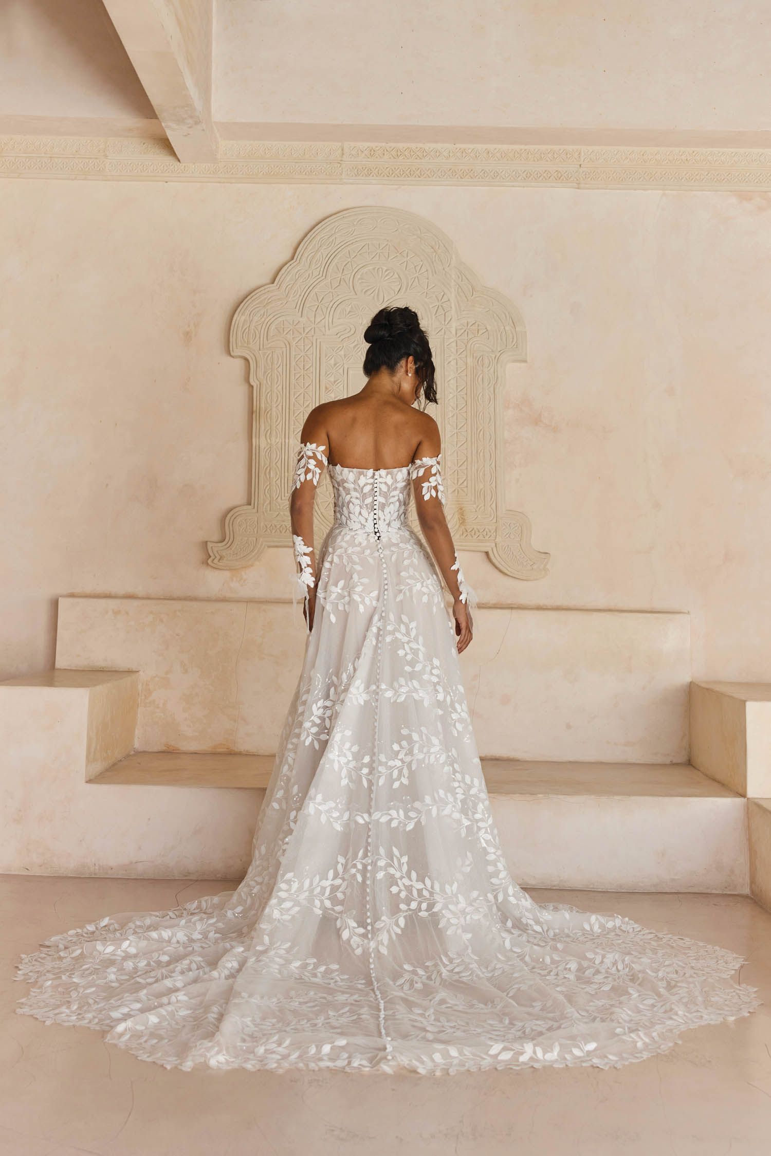 Eine Frau in einem Brautkleid steht in der Wüste.